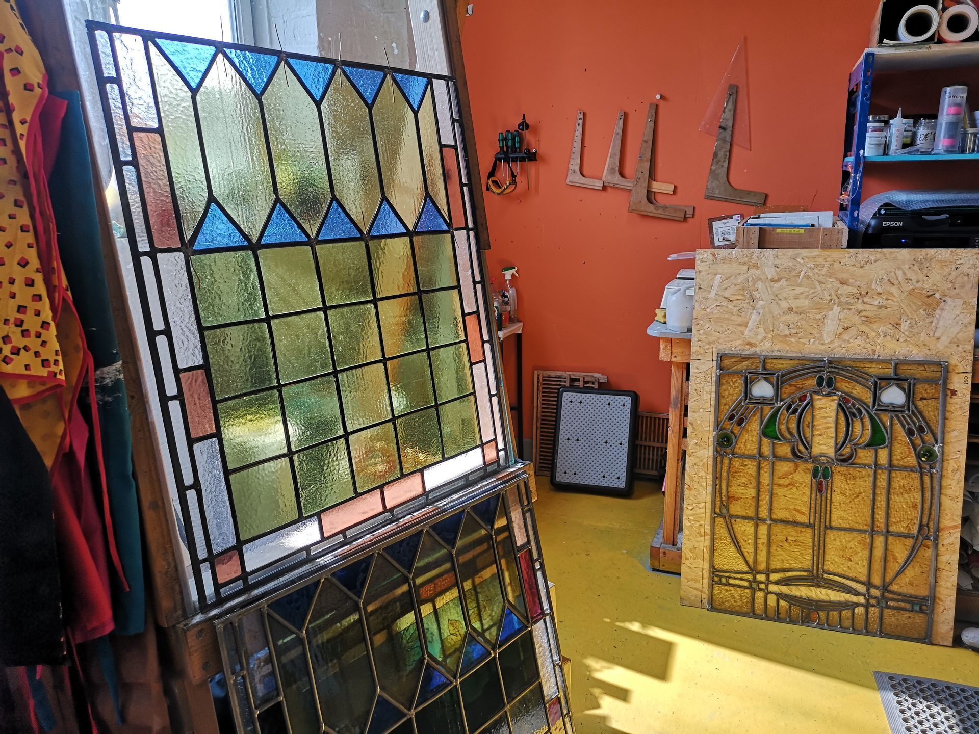 a reproduction stained glass panel on the glass easel in the studio before re installing