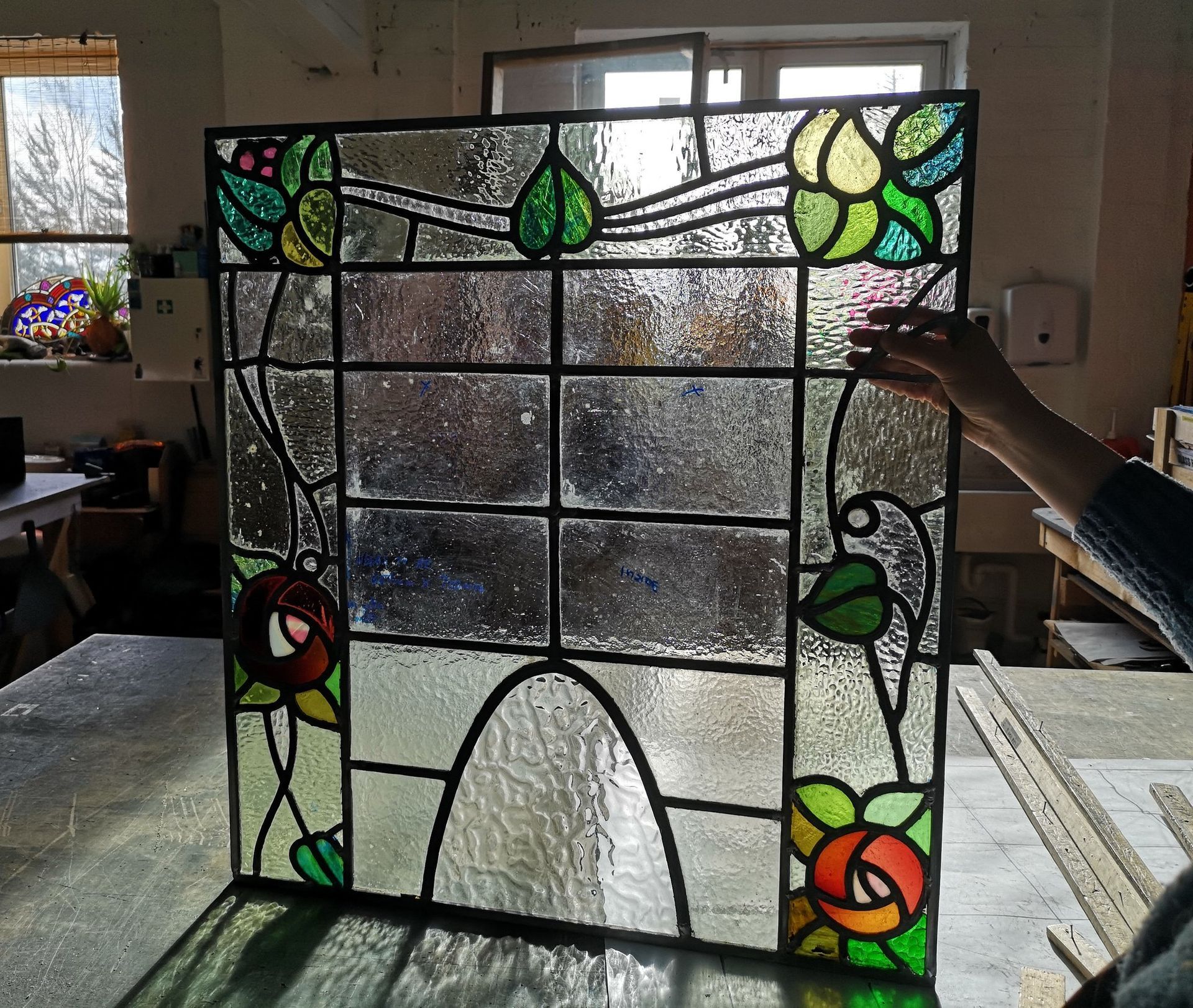 arts and crafts styled stained glass window resized from landscape shape into a portrait position.