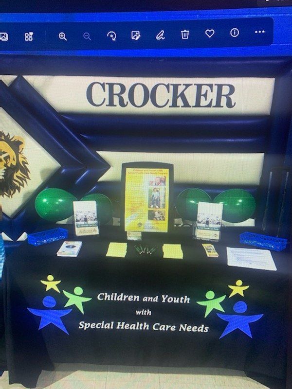 Table with program flyers and balloons displayed.