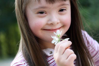 Child smelling a flower.
