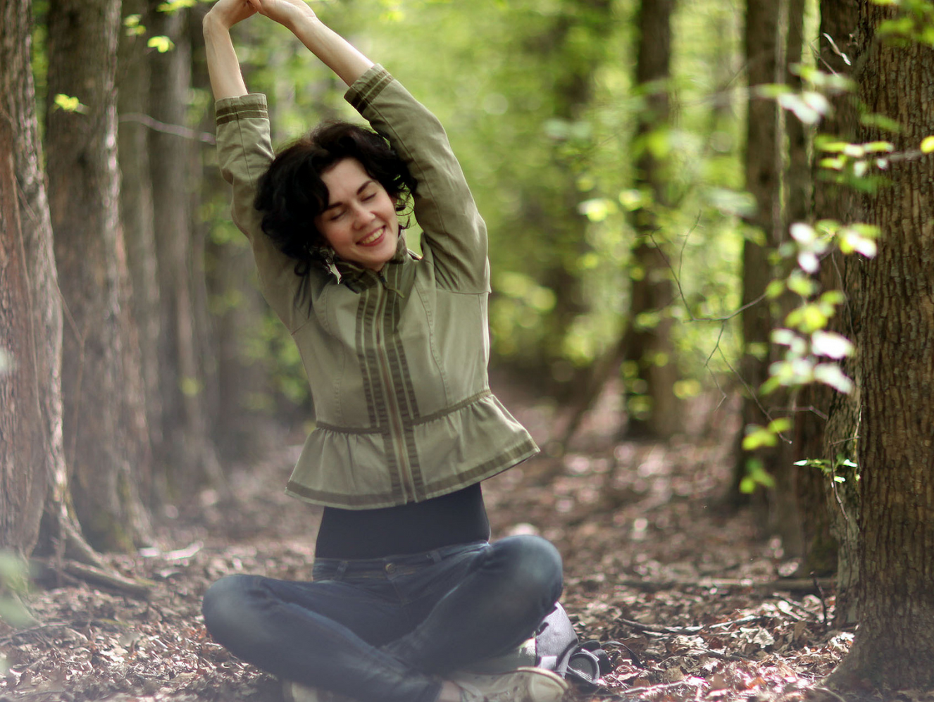 Eine Frau praktiziert Waldbaden im Urlaub als Teil des IM-WALD-SEIN® Medical Wellness Tourismus-Angebots