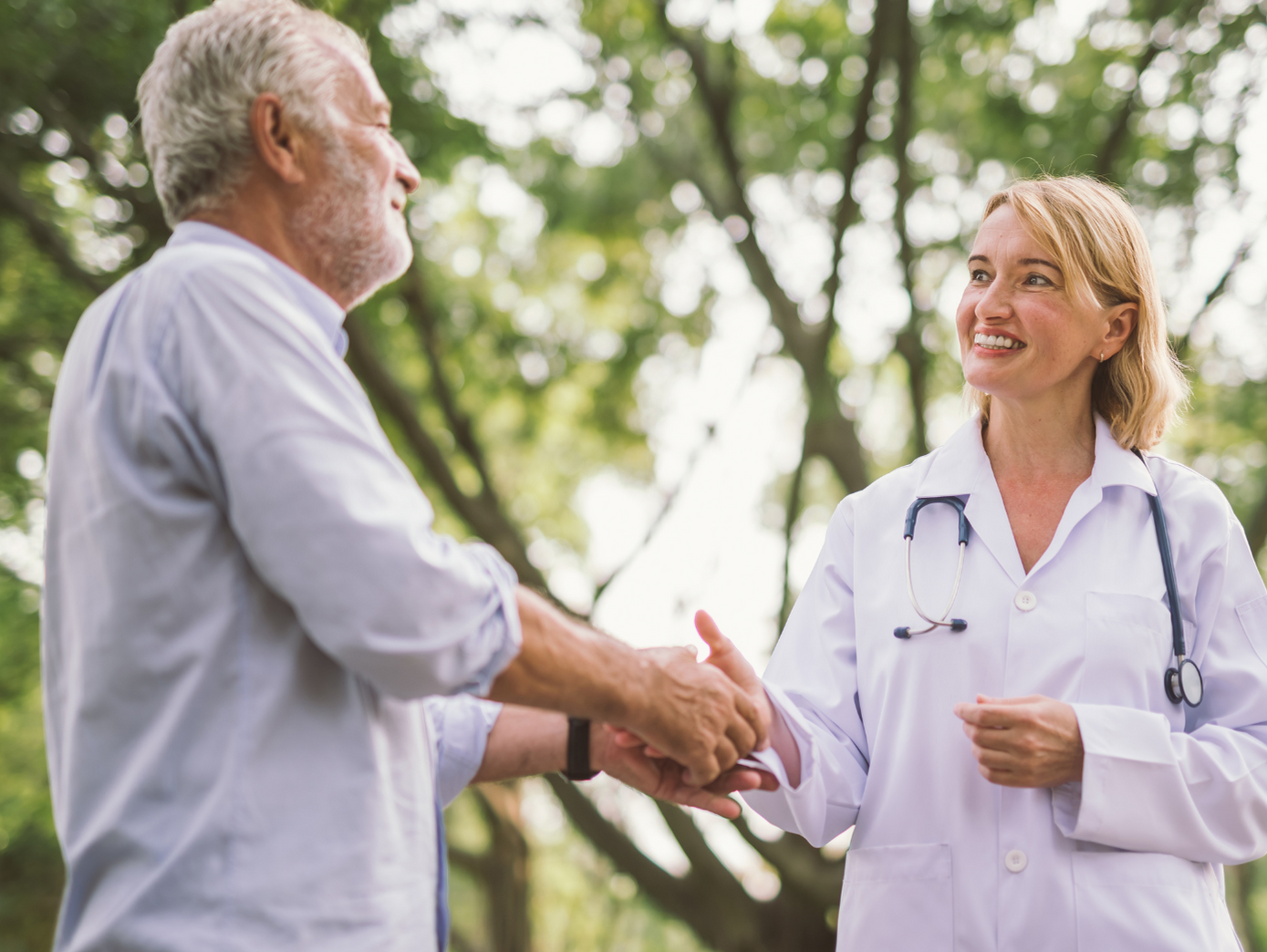 Im Grünen stehend dankt der Patient einer Reha-Klinik seiner Ärztin für die Waldtherapie nach der IM-WALD-SEIN® Methode