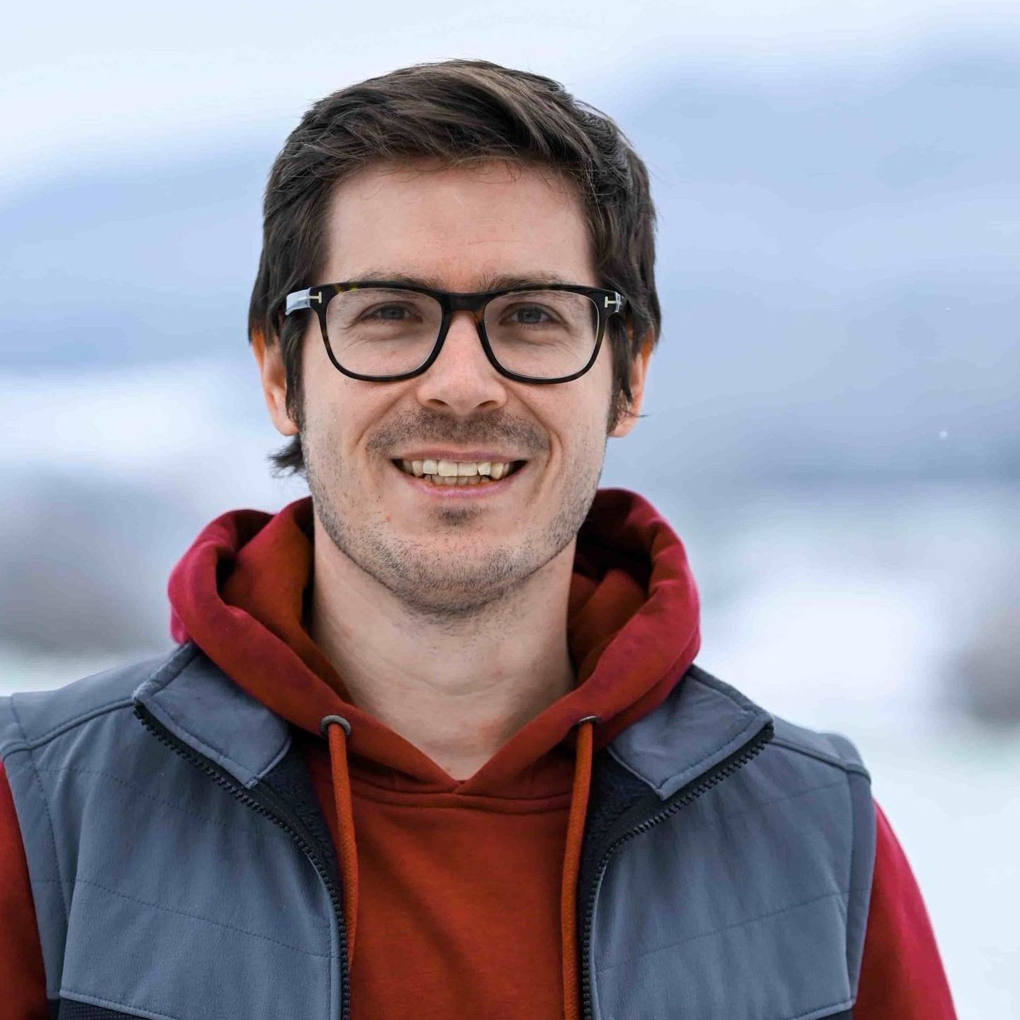 Geschäftsführer von Elektro Schober lacht in die Kamera vor Firmengebäude in Bamberg