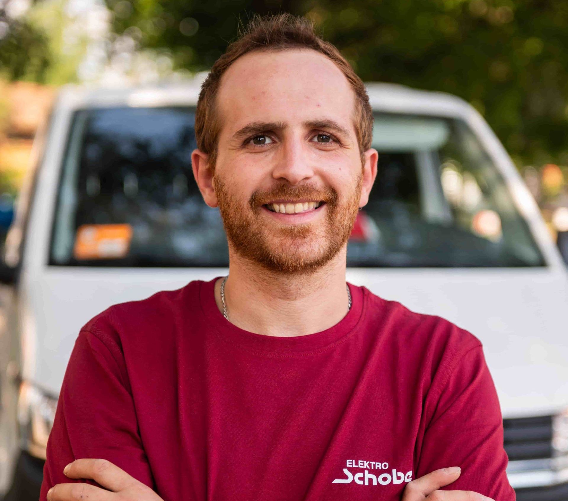 Mitarbeiter von Elektro Schober lacht in die Kamera auf Baustelle in Bamberg