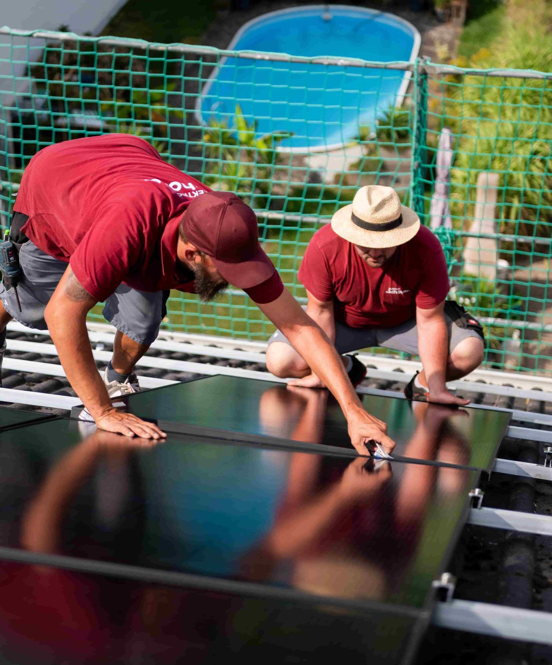 Zwei Mitarbeiter von Elektro Schober montieren Photovoltaikanlage auf Hausdach in Bamberg
