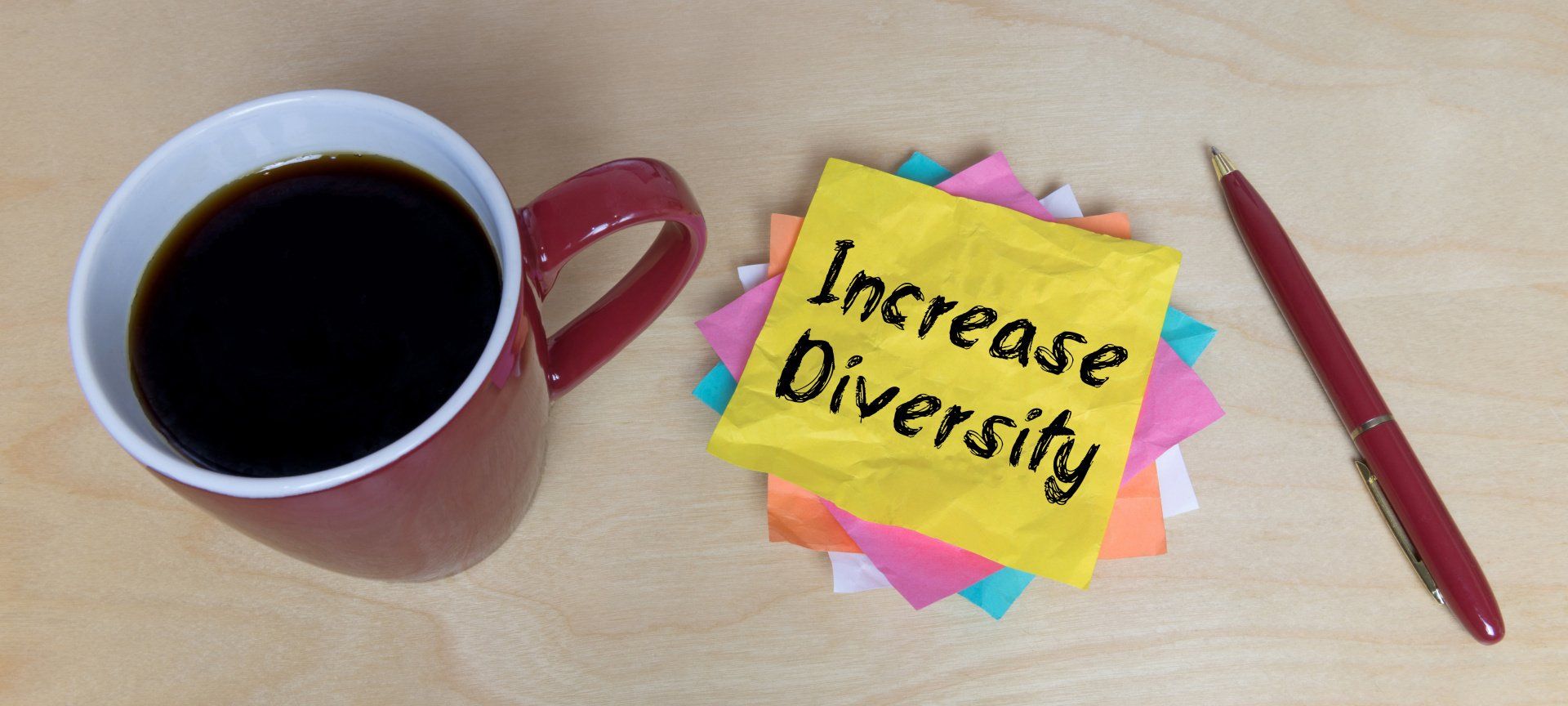 Increase Diversity auf einem Zettel neben einer Tasse Kaffee