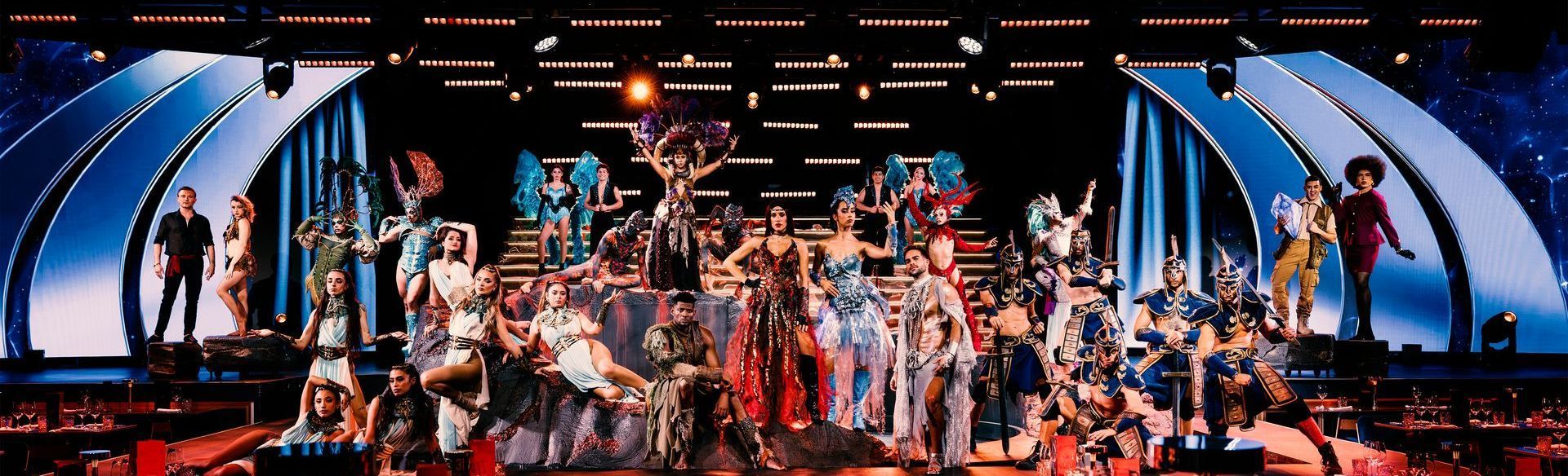 Cast in colorful costumes on stage, scene from the Origen show by Are You Ready