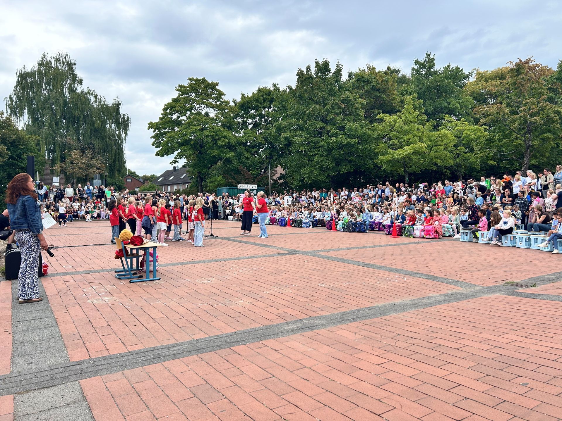 Auftritt des Schulchors auf dem Schulhof, bei dem alle Schulneulinge zuschauen