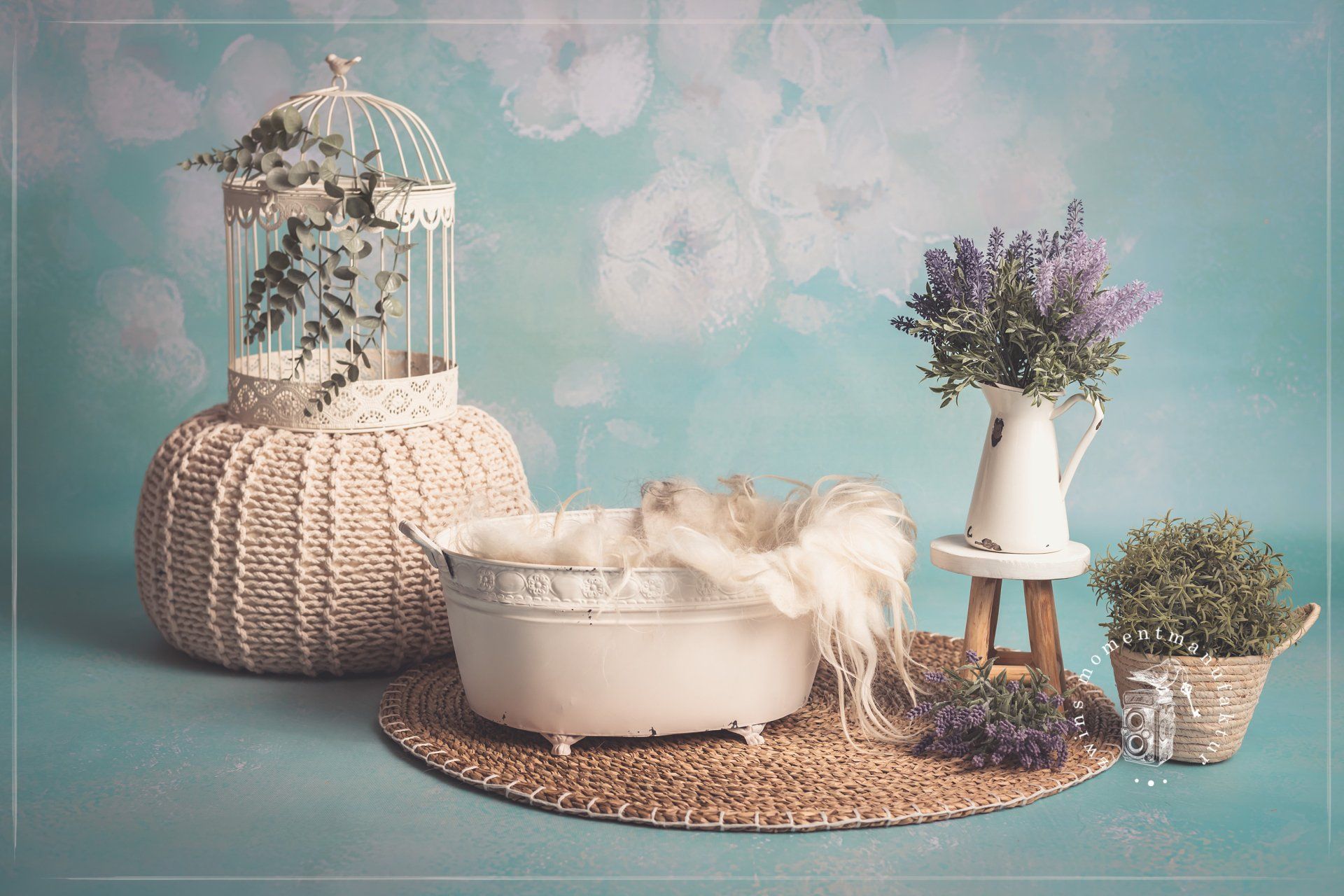 Fotoset für Neugeborene, türkisfarbener Hintergrund mit weißen Blumen, weiße Metallwanne für Babys auf Strohteppich