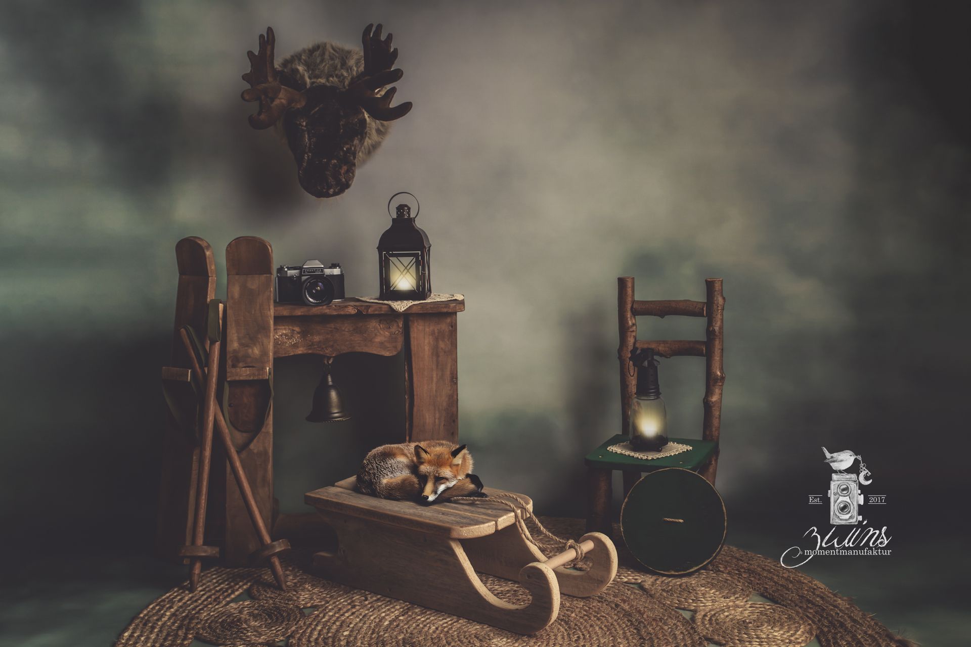 Fotoshooting für Kinder im Fotoset Hüttengaudi mit Holzmöbeln und Schlitten