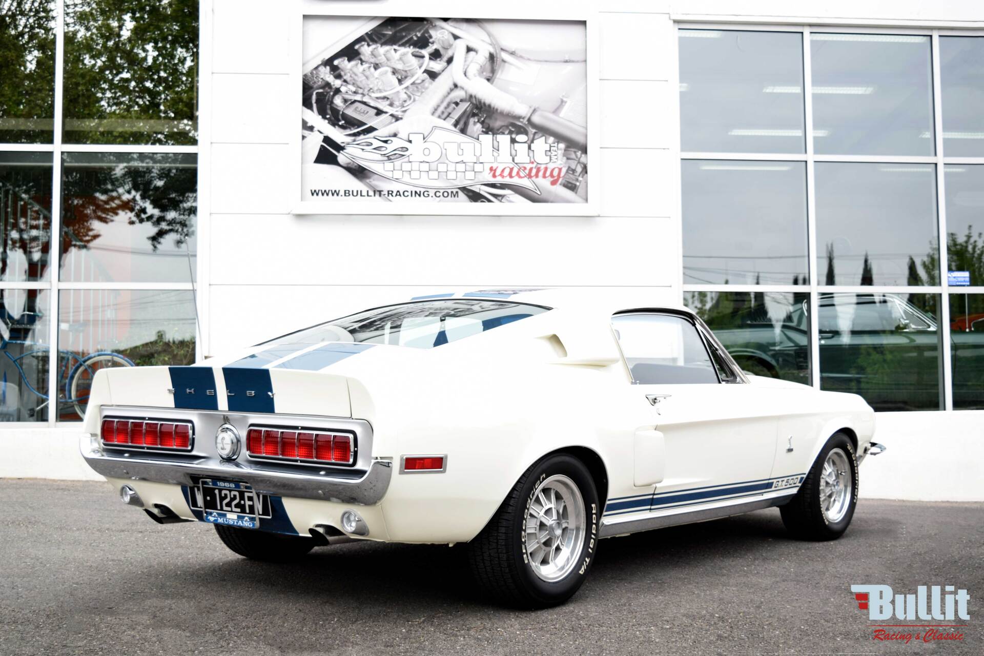 Mustang SHELBY GT 500 de 1968 blanche avec bandes bleues vue de 3/4 arrière droit