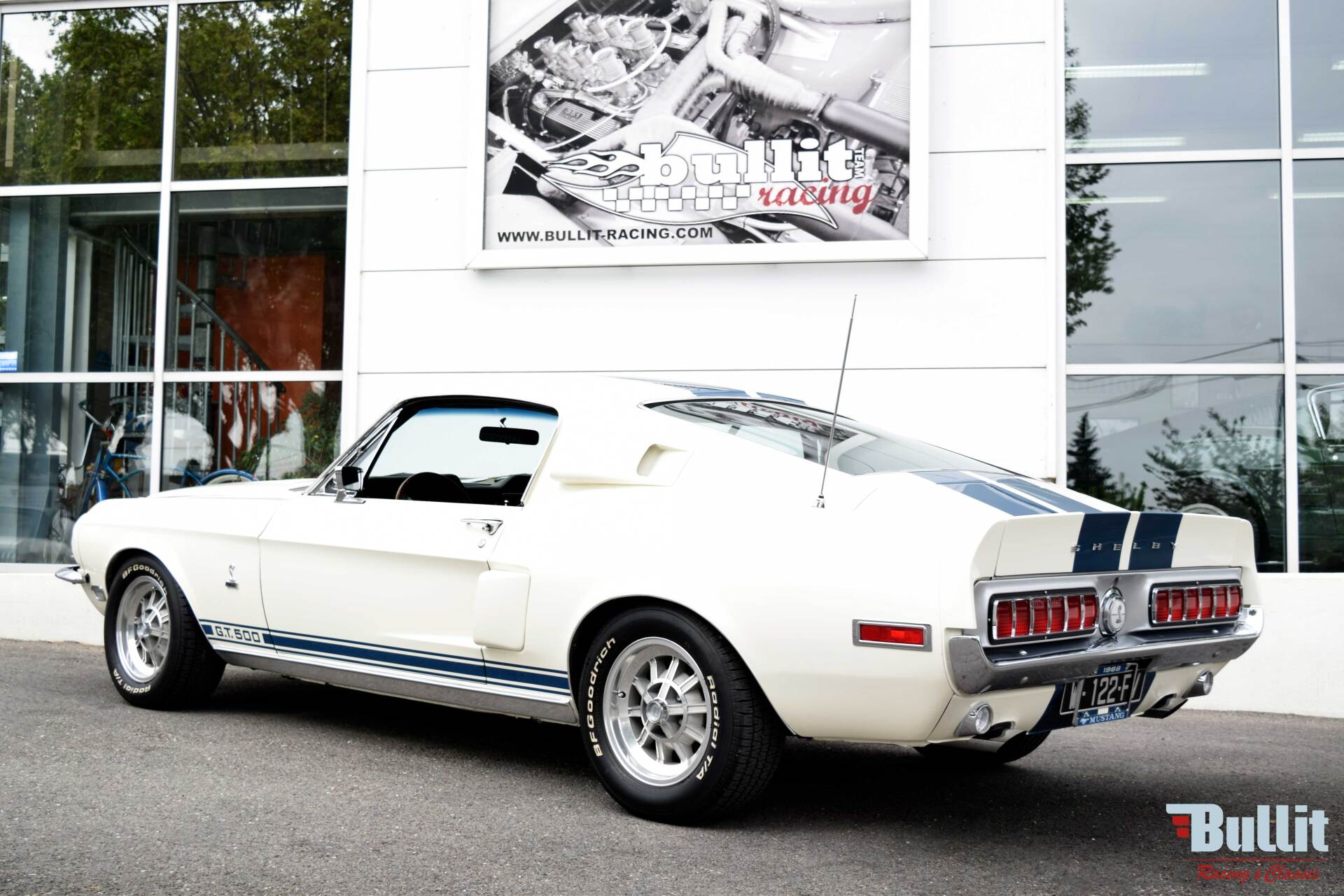 Mustang SHELBY GT 500 de 1968 blanche avec bandes bleues vue de 3/4 arrière gauche