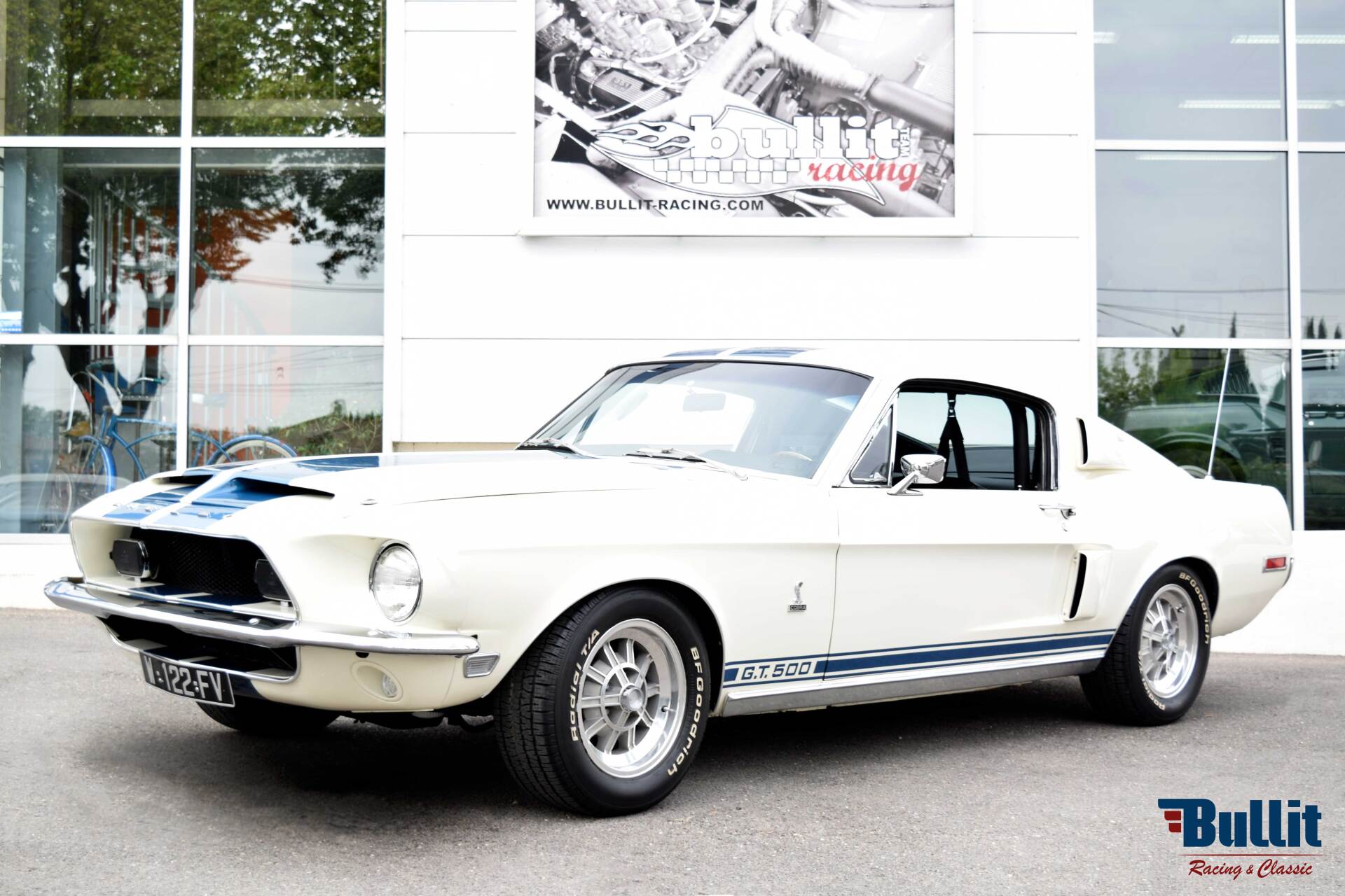 Mustang SHELBY GT 500 de 1968 blanche avec bandes bleues vue de 3/4 avant gauche