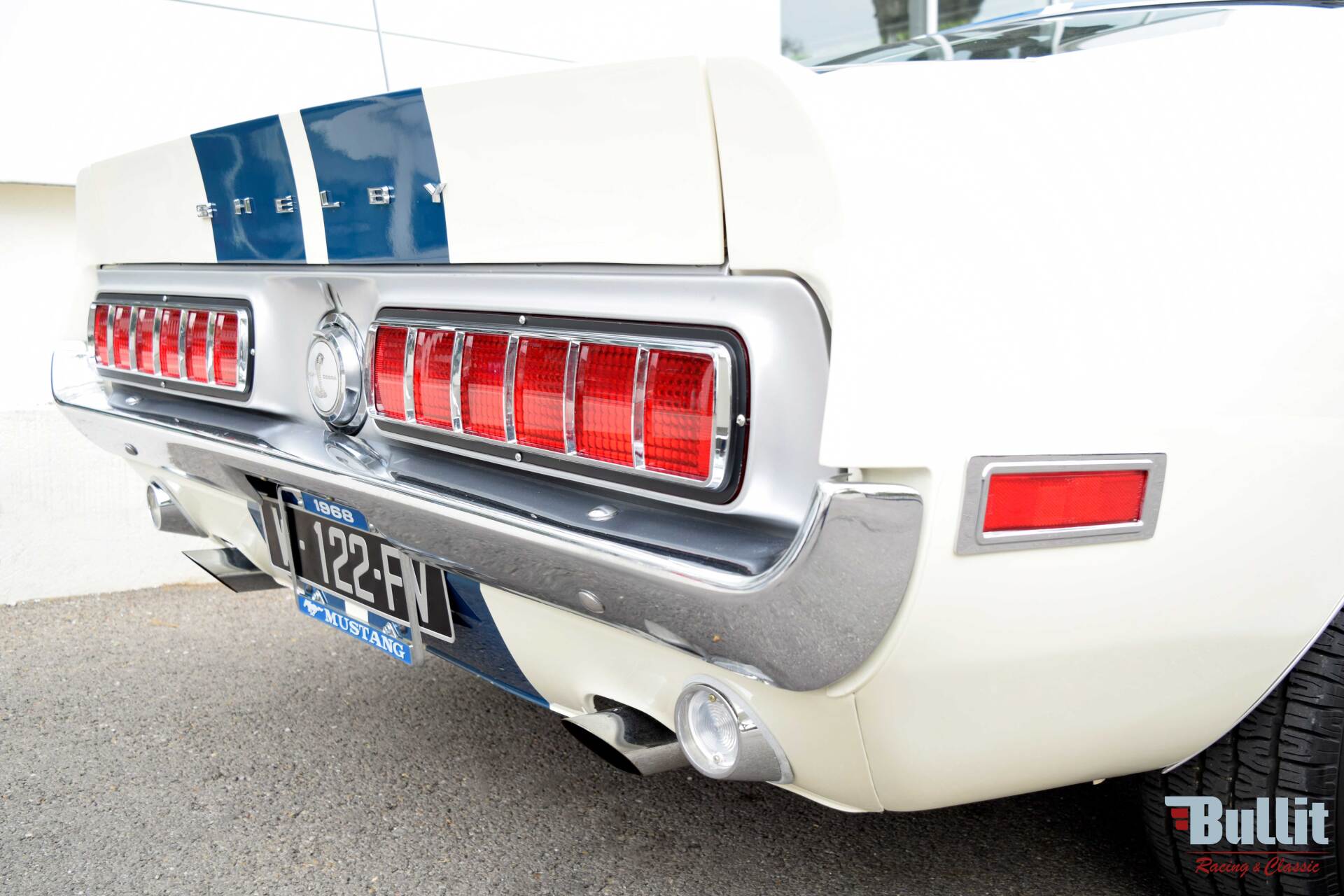 arrière de Mustang SHELBY GT 500 de 1968 blanche avec bandes bleues