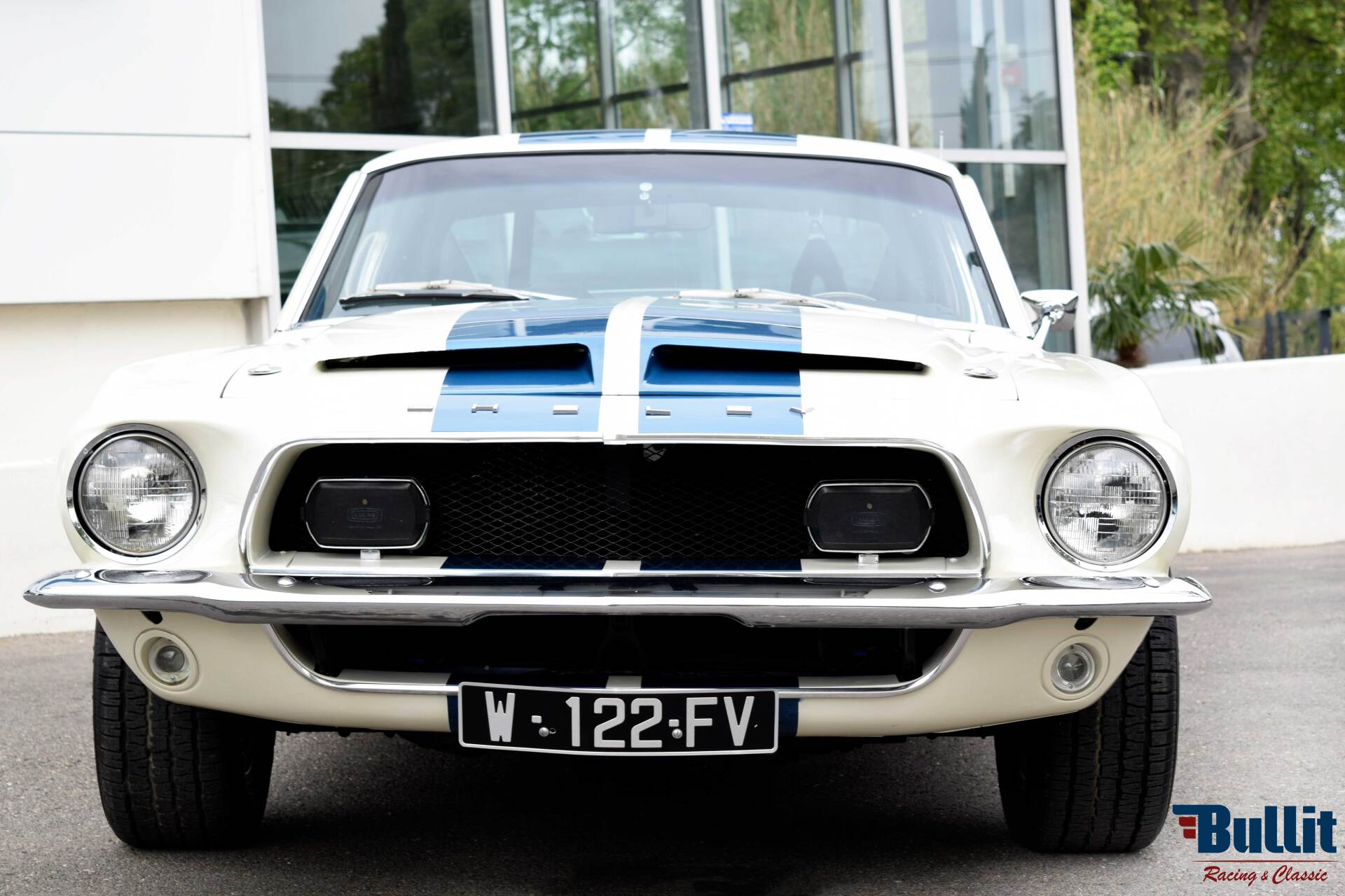 avant de Mustang SHELBY GT 500 de 1968 blanche avec bandes bleues