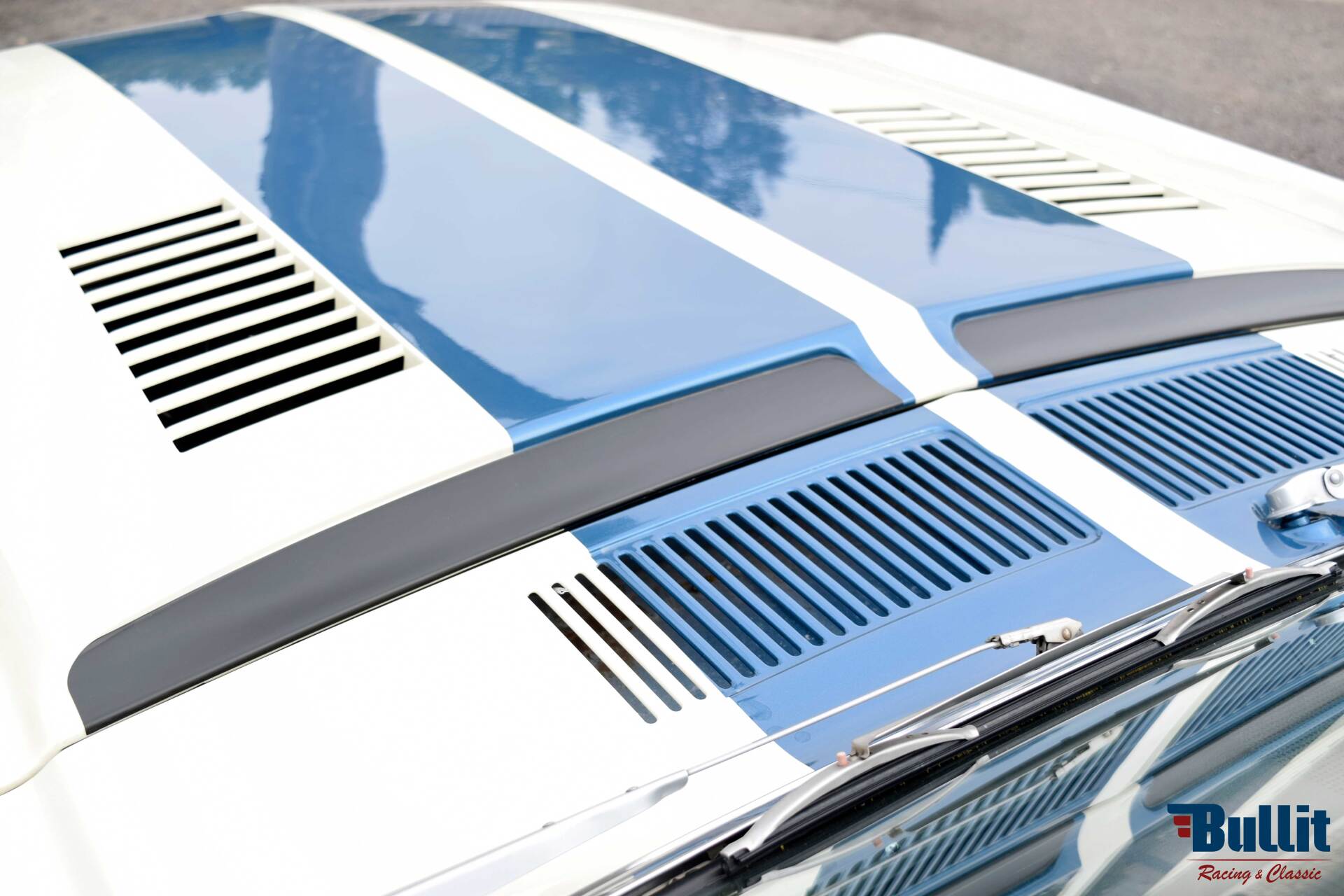 détail de Mustang SHELBY GT 500 de 1968 blanche avec bandes bleues