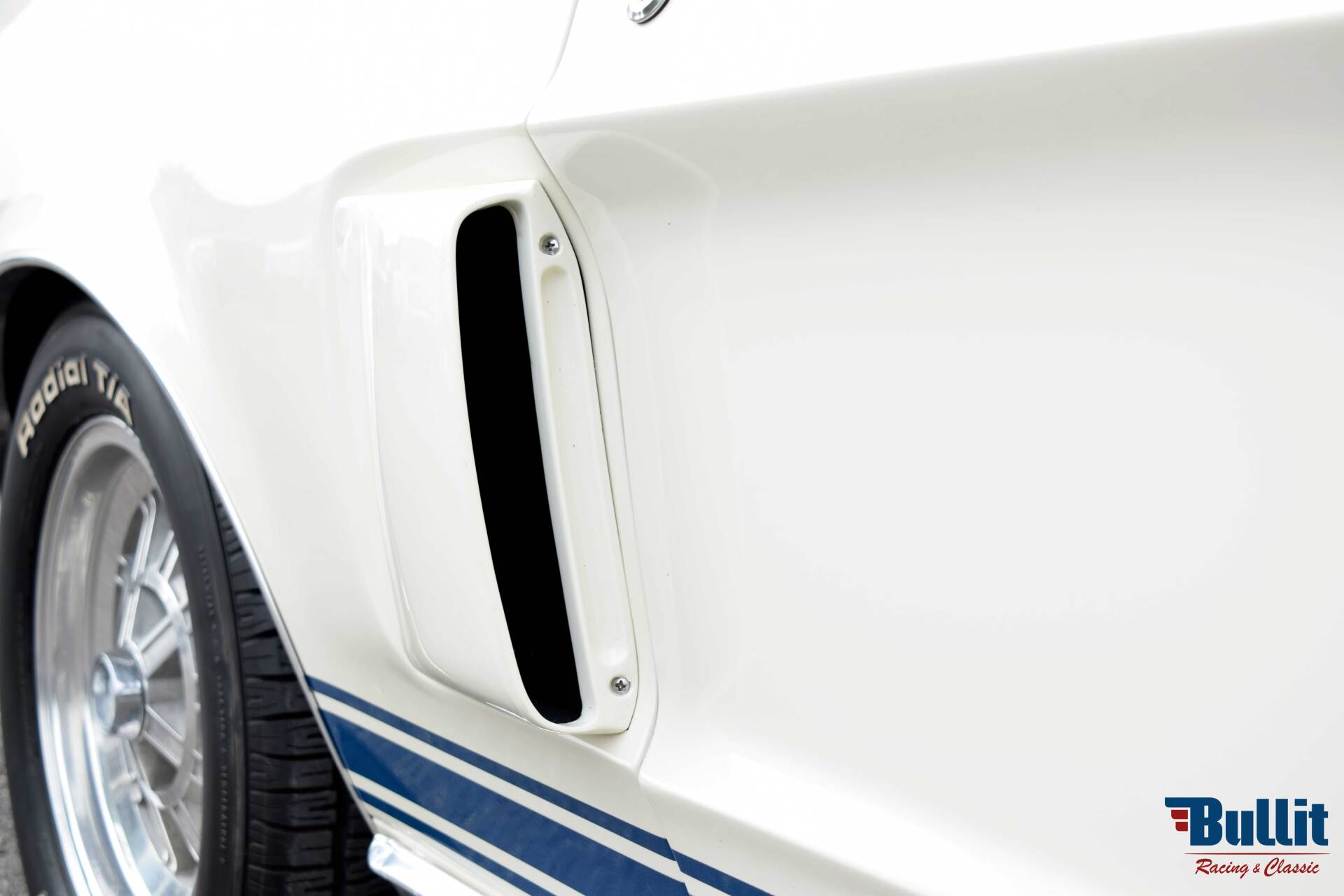 détail prise d'air de Mustang SHELBY GT 500 de 1968 blanche avec bandes bleues
