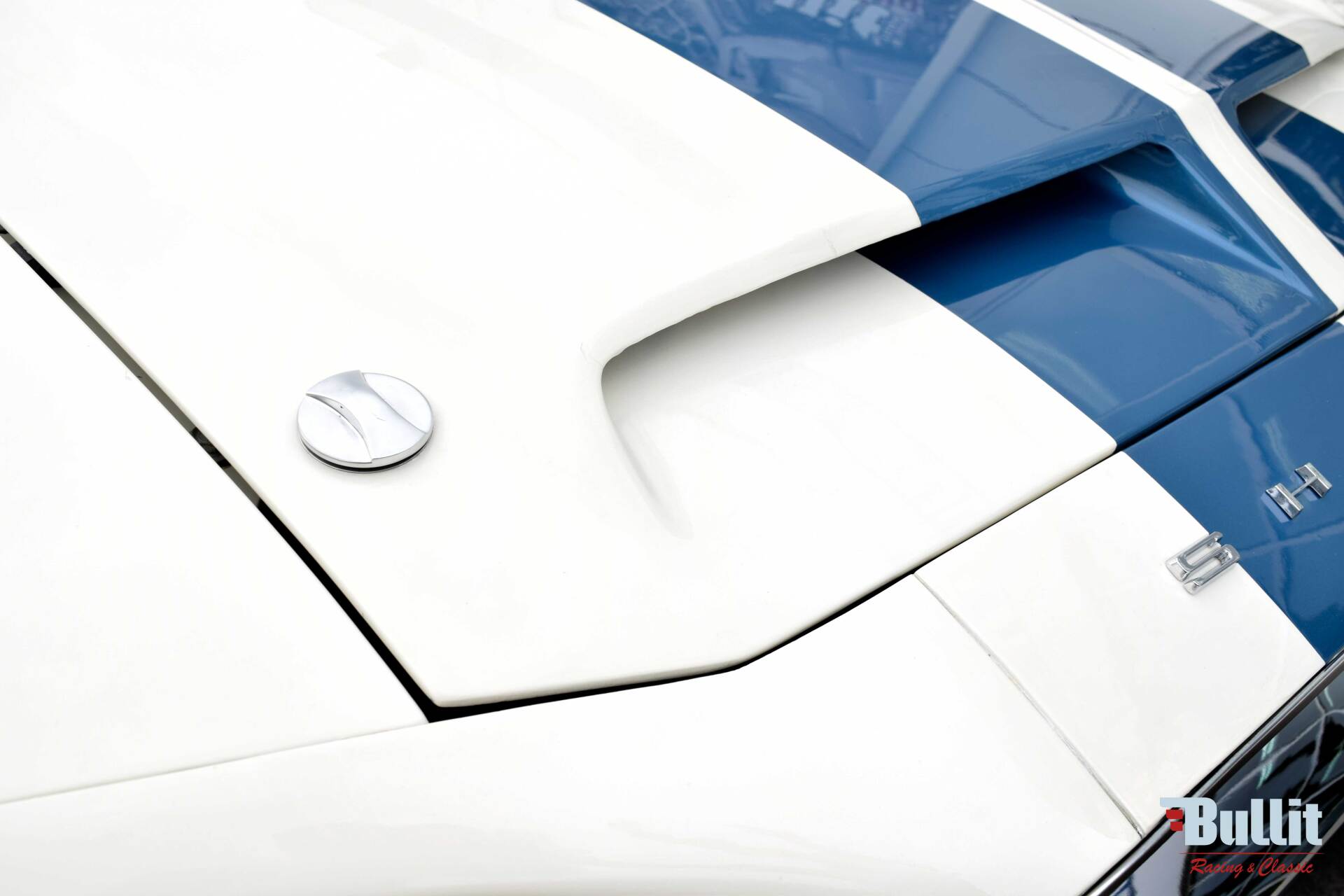détail de Mustang SHELBY GT 500 de 1968 blanche avec bandes bleues