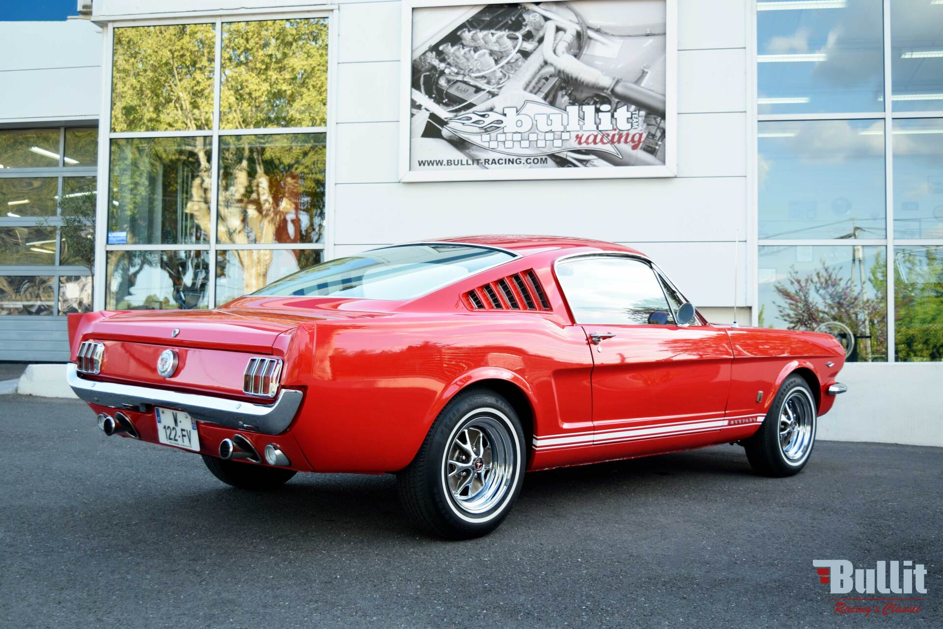 Ford Mustang 2+2 Fastback GT rouge de 1965 vue de 3/4 arrière droit