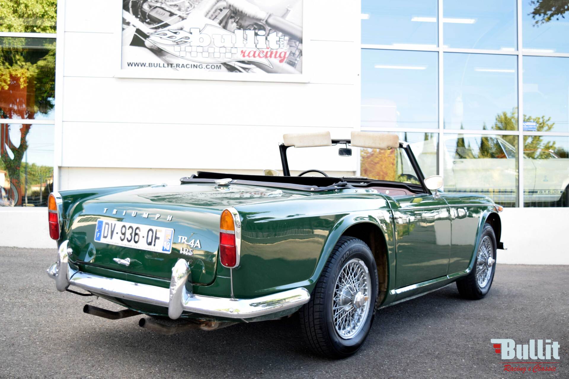 Triumph TR4 A irs de 1966 vert intérieur noir vue de 3/4 arrière droit