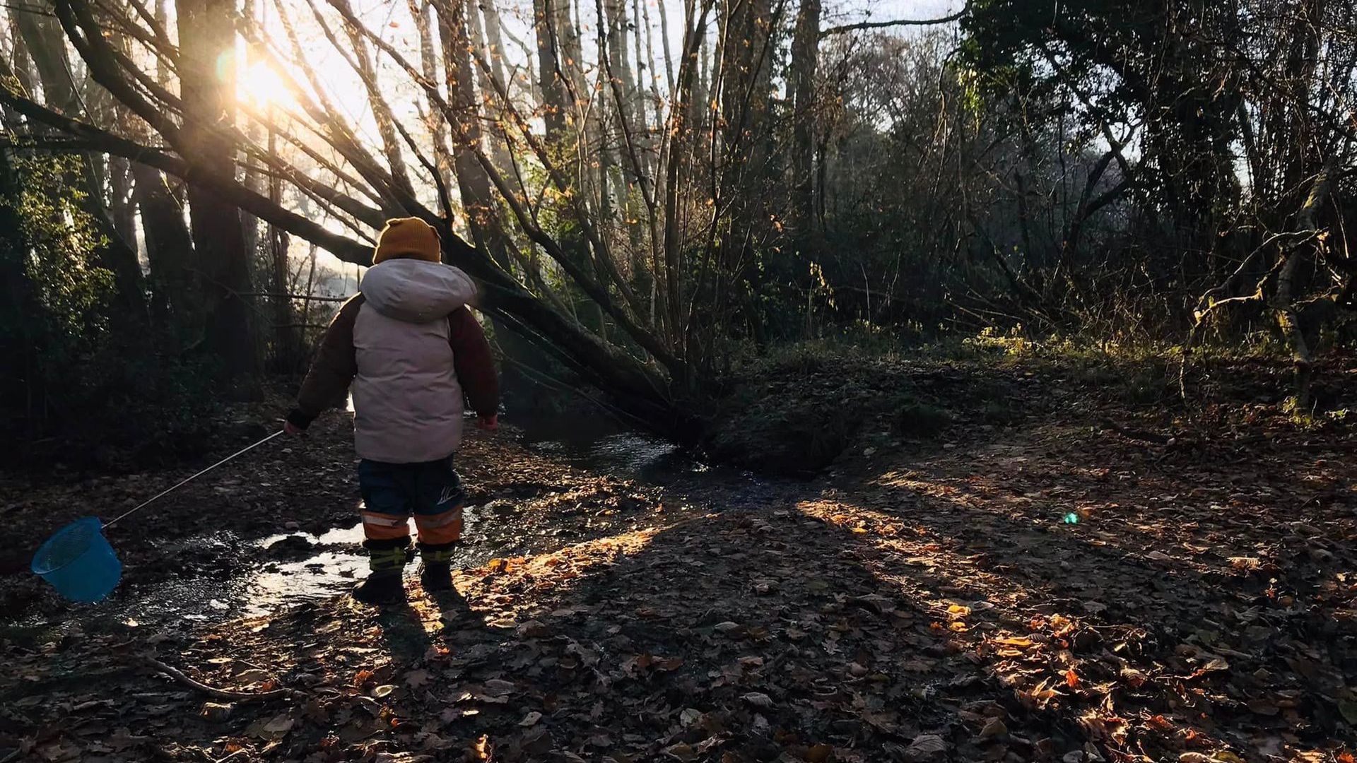 Toddler playing in the mud with a stick
