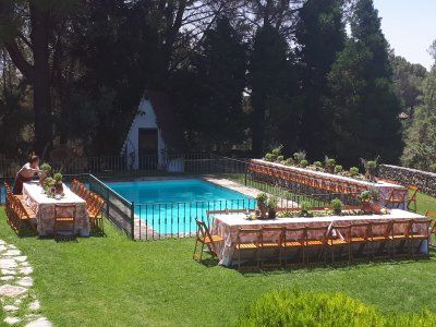 Montaje de mesas y sillas en jardín con mesas rectangulares para la celebración de una comunión