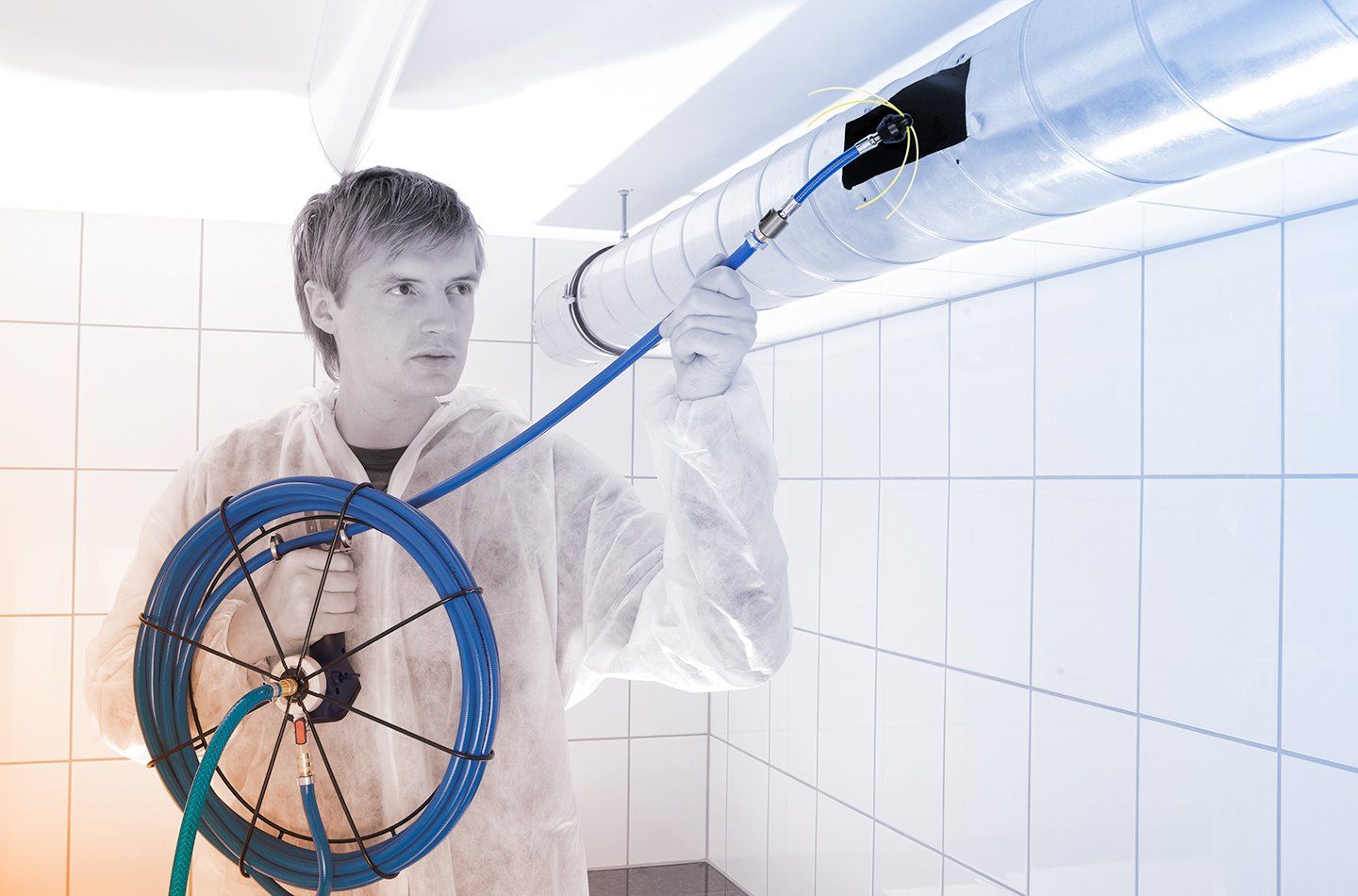 Professionelle Reinigung eines Lüftungsrohres Mitarbeiter reinigt mit Hilfe einer Druckluftpeitsche