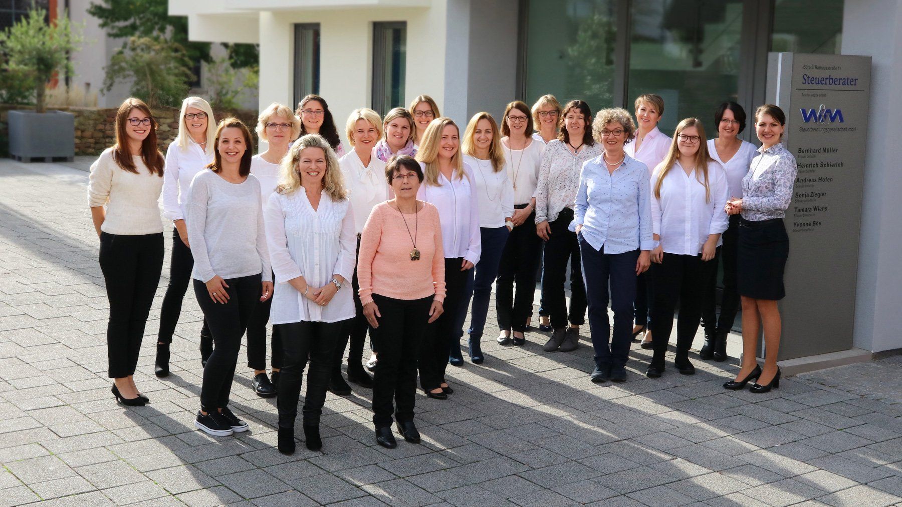 Das Team von W+M Gruppenbild mit einem Teil des Teams von W+M am Standort Leimen. Alle Personen stehen auf dem Platz vor dem Eingang von Büro 2.