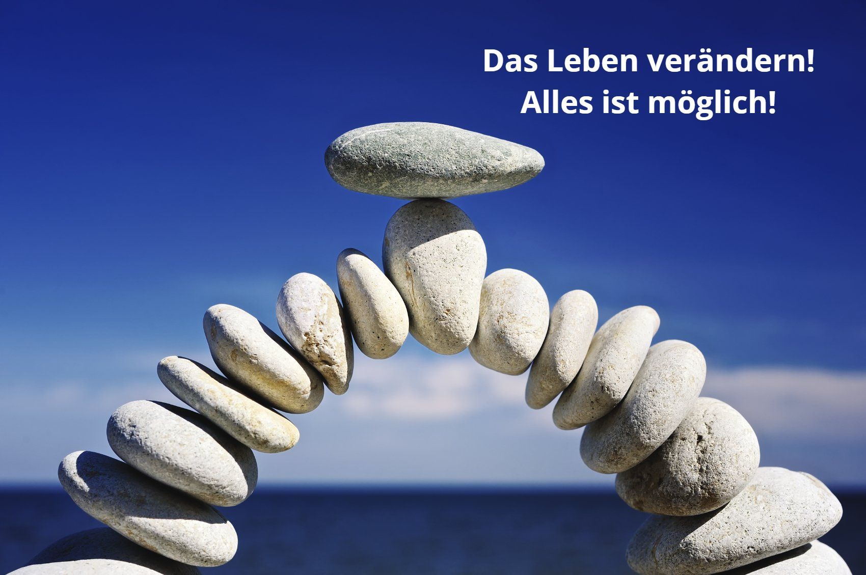 Ein Steinbogen mit einem balancierten Stein oben. Als Text