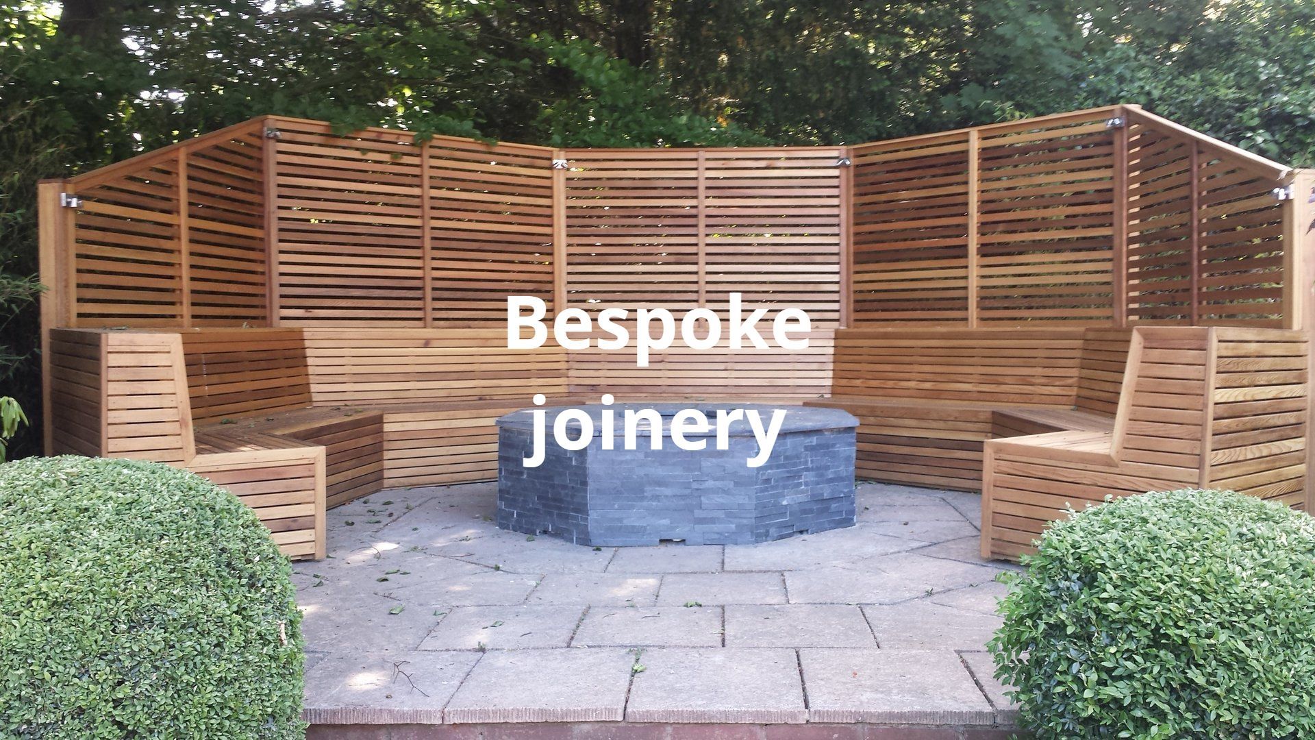 Bespoke outdoor seating designed and built and varnished. with and slate firepit in Windsor.