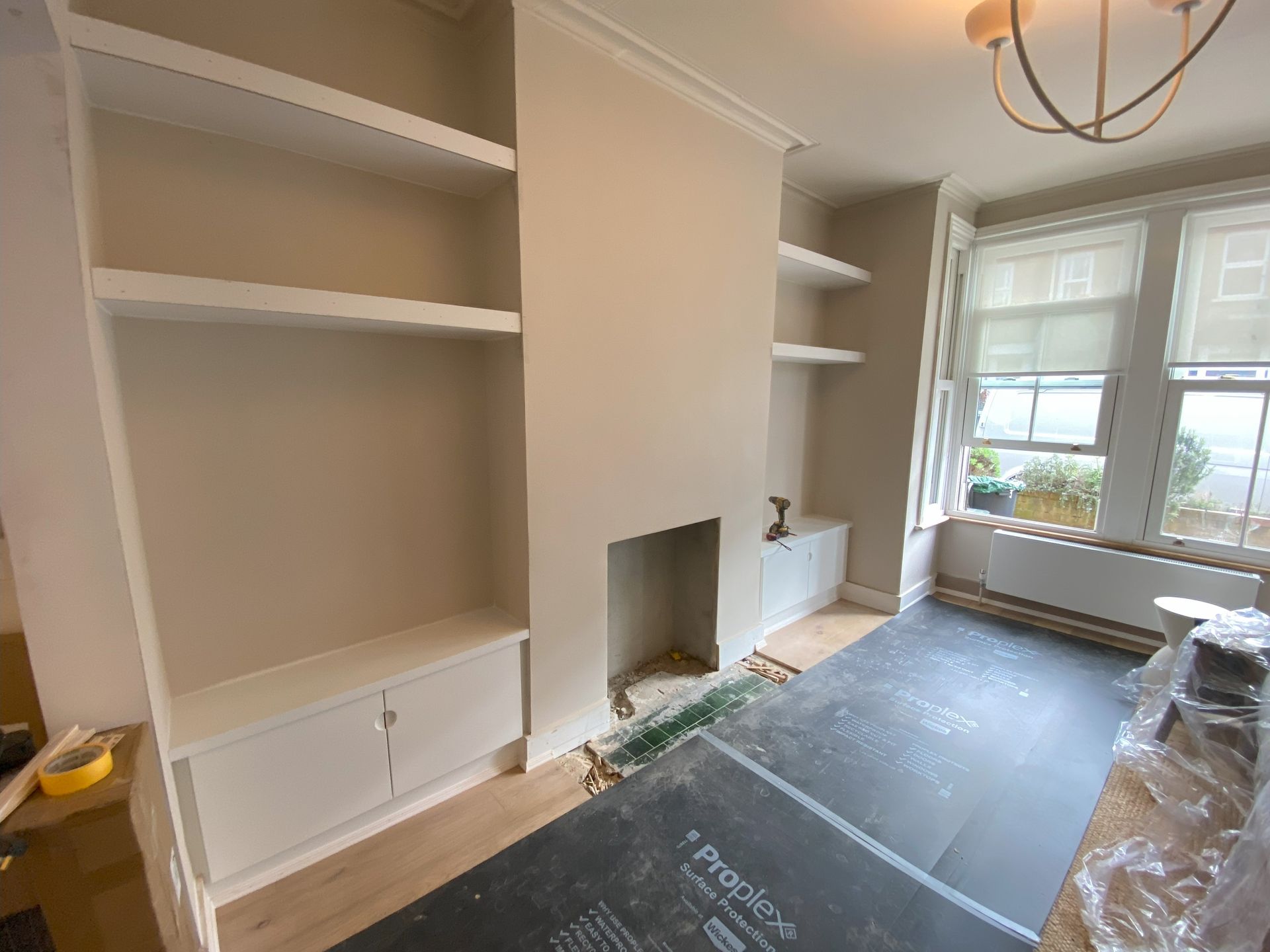 The alchove units are fitted between a fireplace to give the room definition and a smart storage solution. The doors have a fluted handle which is a super modern look at the moment. There are chunky wieght bearing shelves above. Take a look at hese cool alchove units and floating shelves we installed