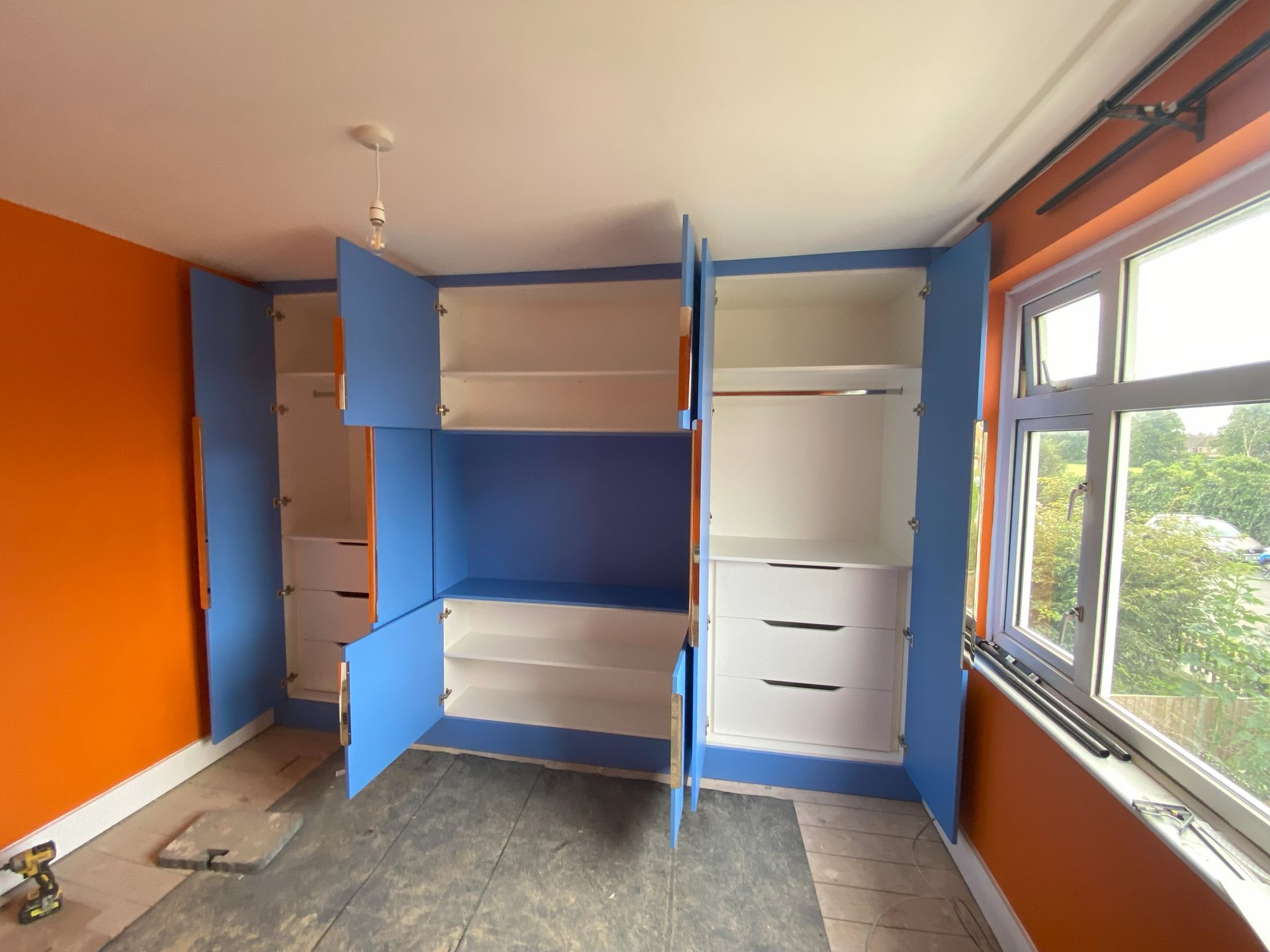 Check the cool contrasing bedroom wardrobe we installed in Molesey. It has built in drawers, shelves and hanging rails.