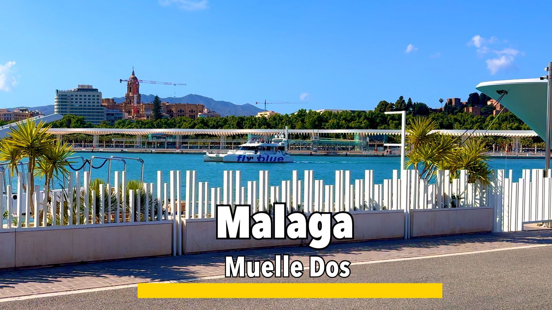 Muelle Dos promenade in Málaga, featuring a long shaded walkway with a unique parasol structure and views of the harbor