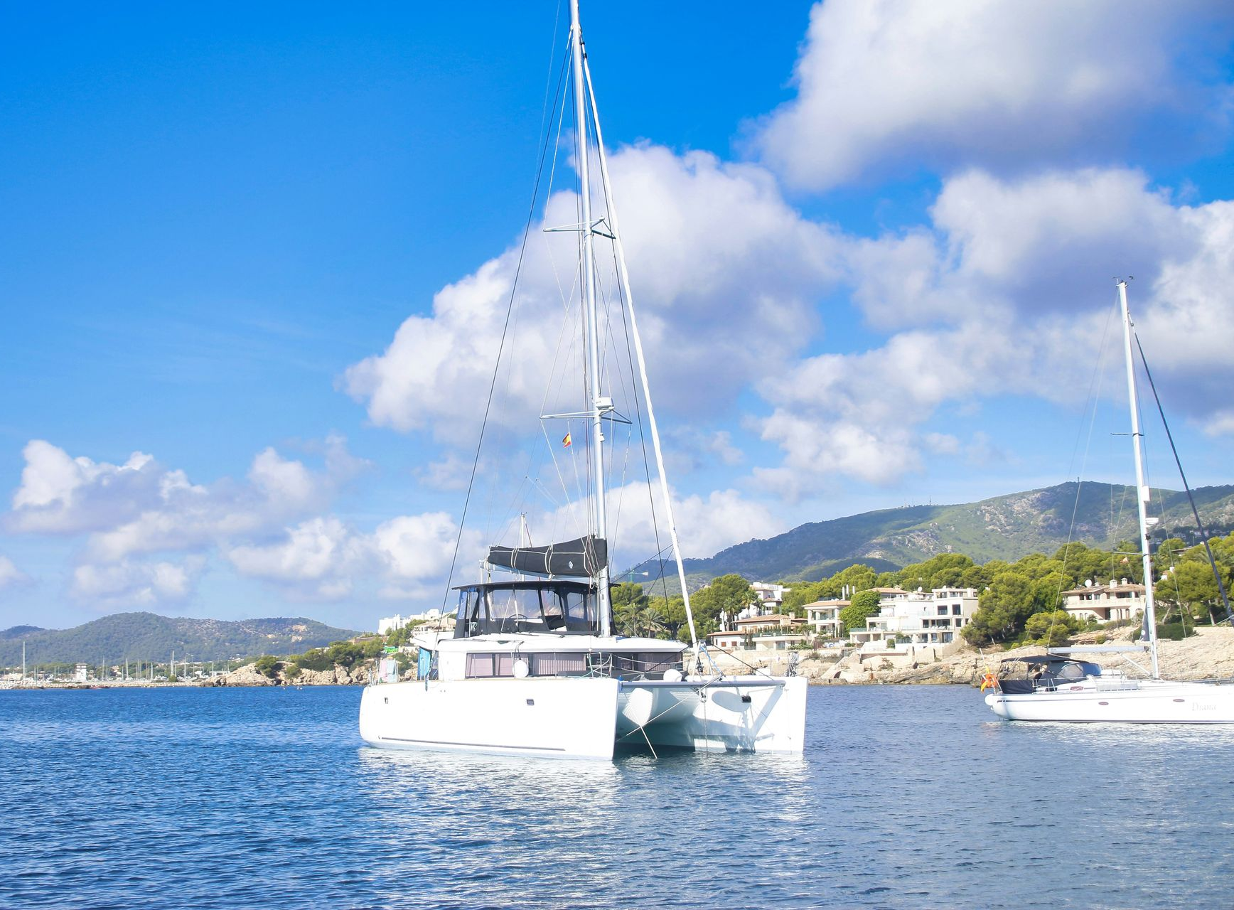 Katamaran und Segelyacht in einer Bucht auf Mallorca