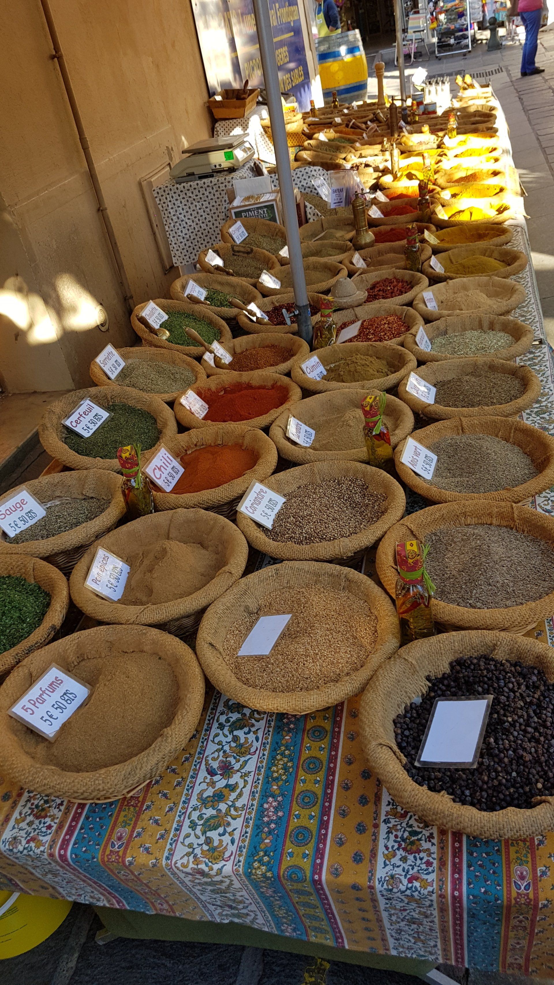 Tisch mit vielen verschiedenen Gewürzschale in bunten Farben