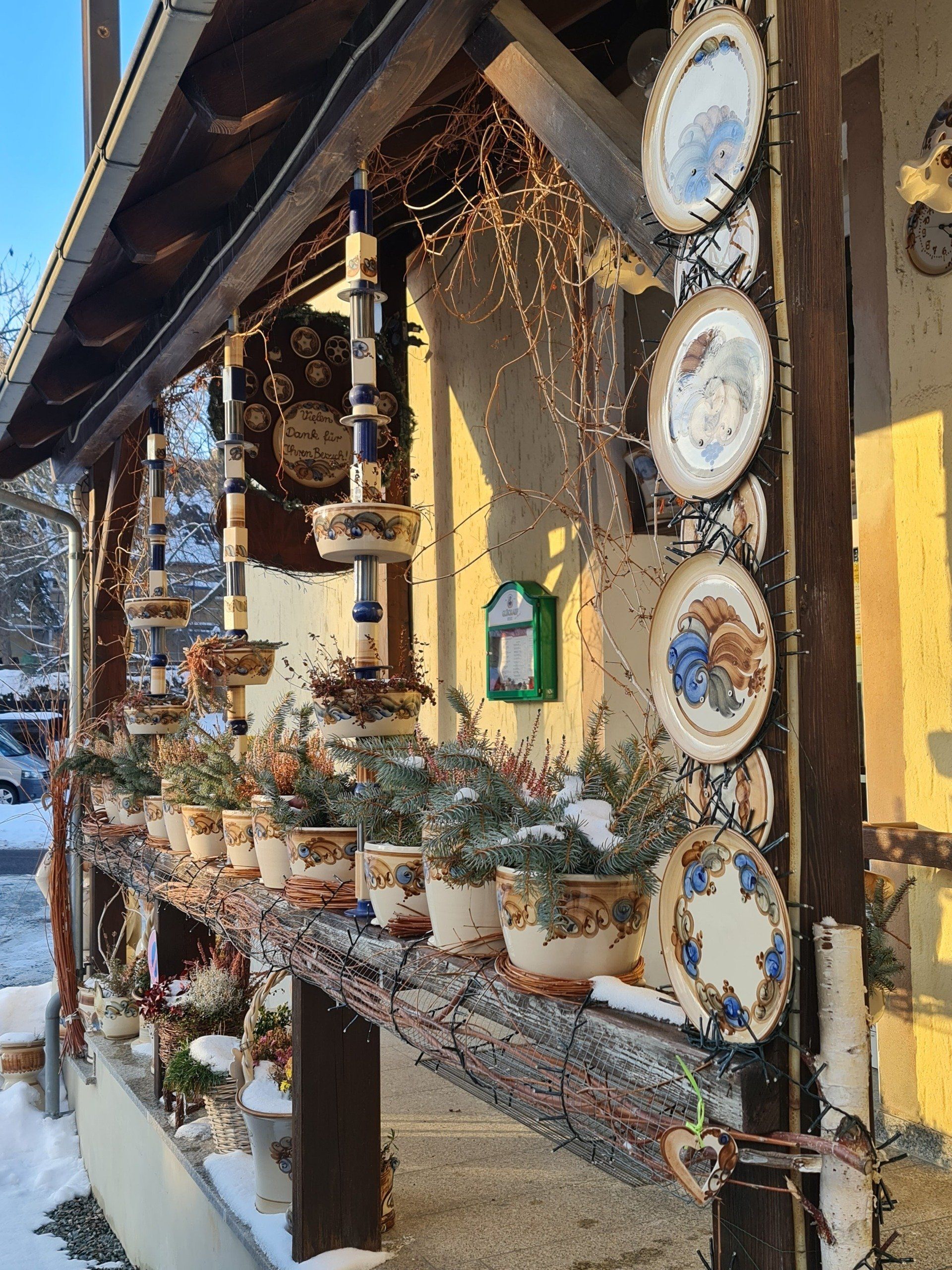 Keramikteller auf einem Geländer und weihnachtlich Deko bei Heyde Keramik im Erzgebirge