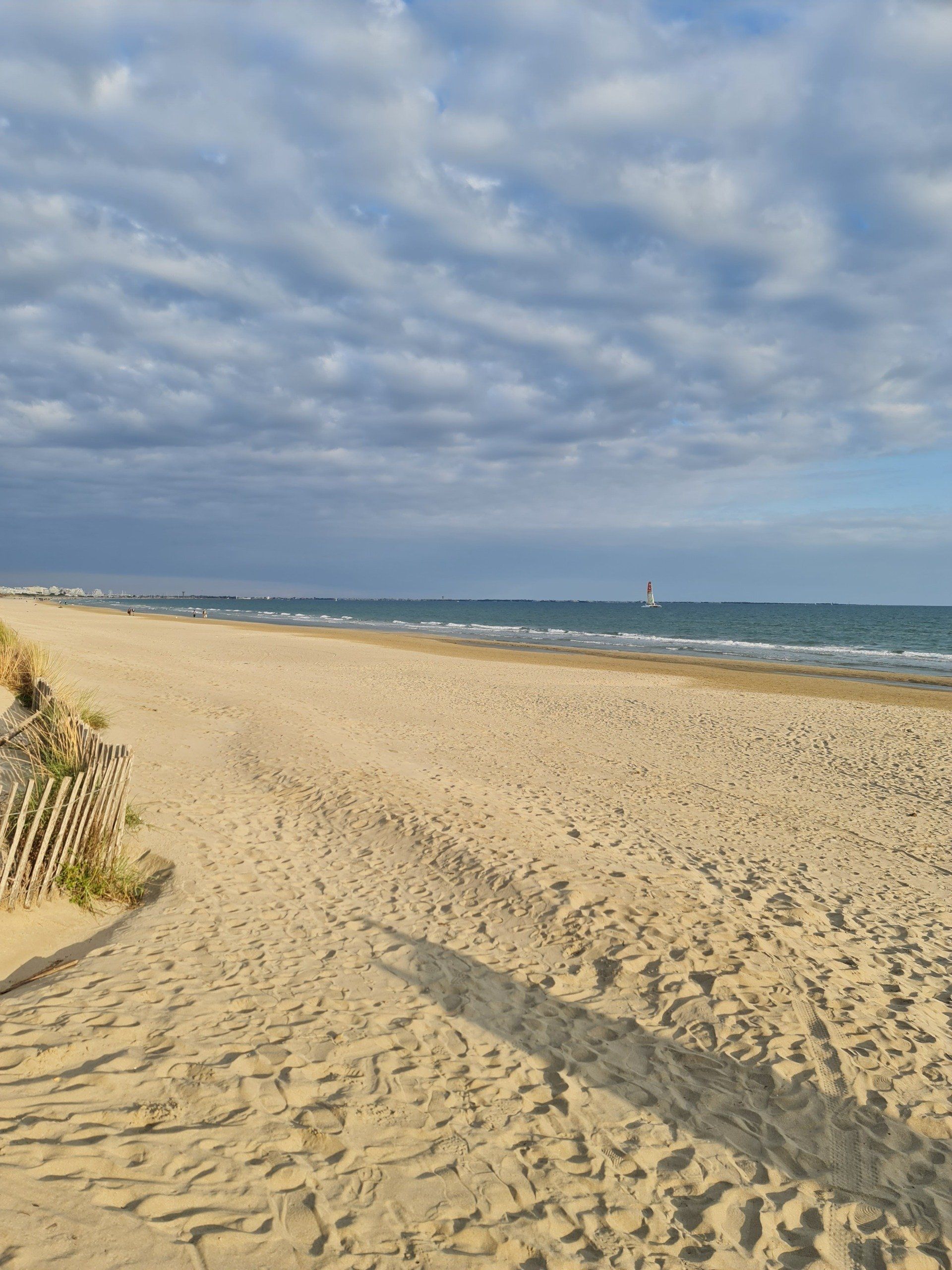 Strand mit blauem Himmel und kleinen Wolken