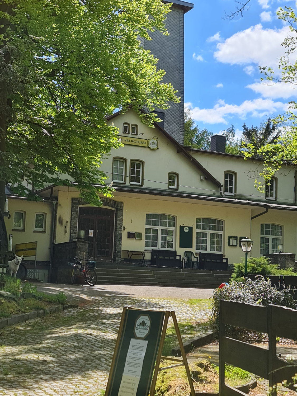Ein Haus mit einem Turm aus Schiefer mitten im Wald Gaststätte Adelsbergturm bei Chemnitz