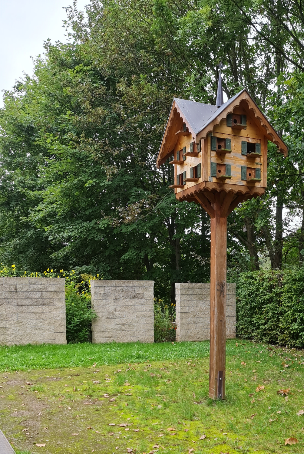 Ein schönes Vogelhaus bietet eine Menge Platz für die Bewohner -gefunden im Bürgerpark in Oelsnitz im Erzgebirge Photo by: Viola Einert-Krug verziertes Vogel und Taubenhaus mit vielen Fenstern und 2 Dächernauf langem Holzstab im Bürgerpark Oelsnitz Erzgebirge