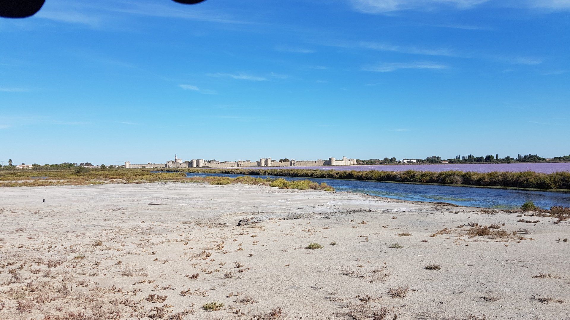 Salzsee in blau und lila vor der Festung Aigues Mortes