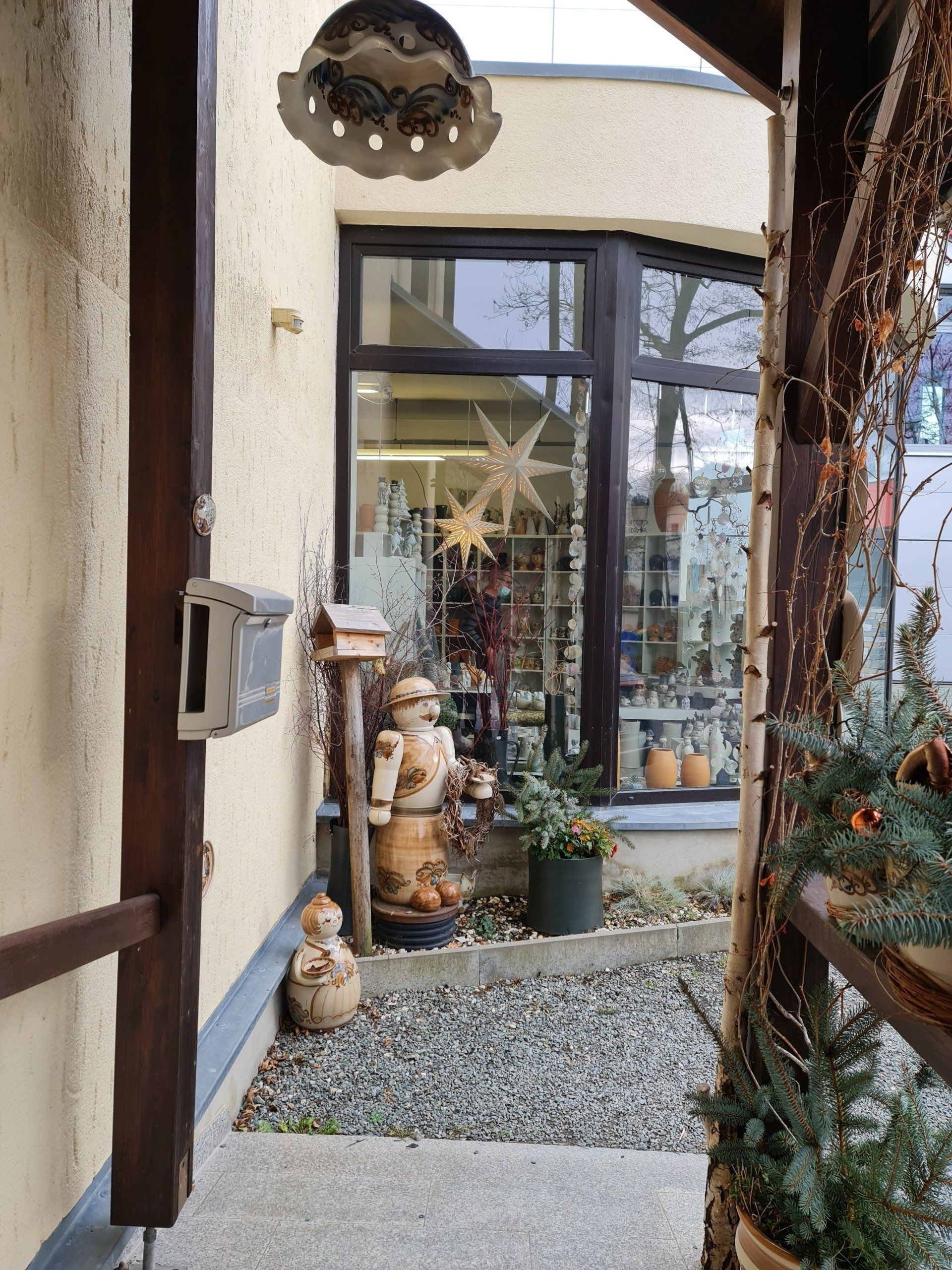 Wintergarten mit Ausstellungsstücken aus Keramik davor und hinter der Scheibe bei Heyde Keramik in Jahnsdorf