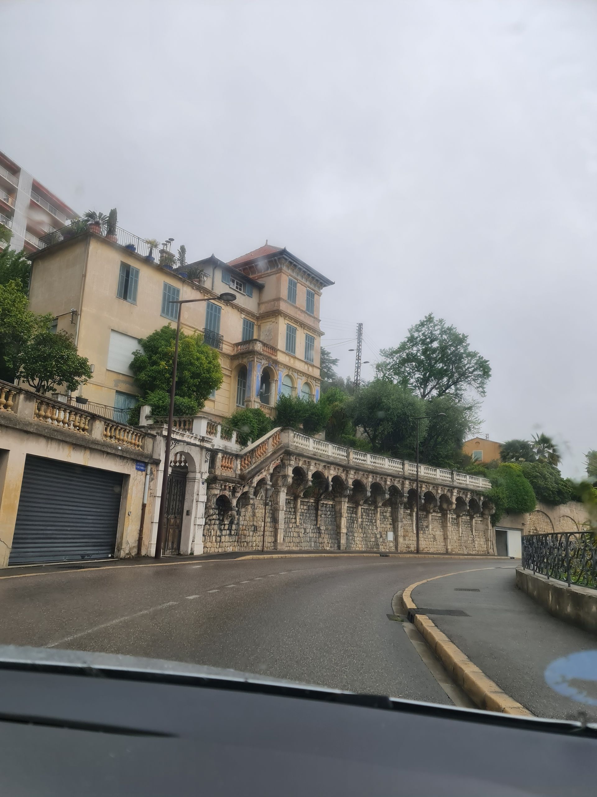 Ein Palais aus gelbem Stein im Regen an der Straße in die Berge
