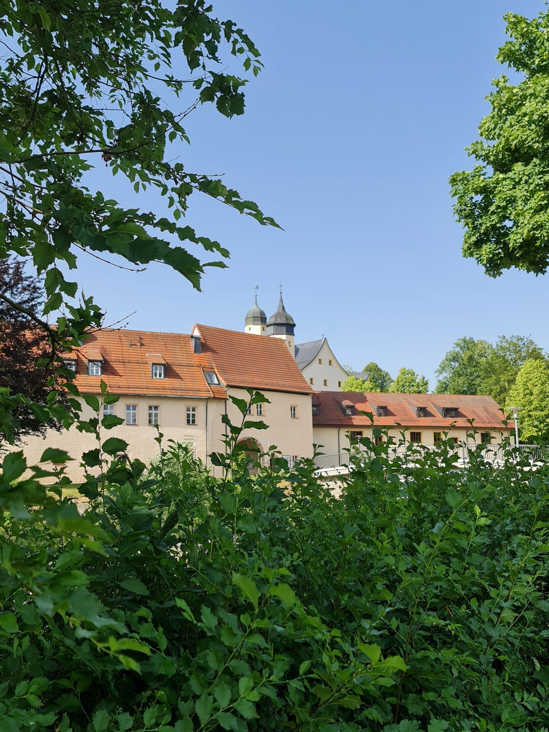 Ein Schloss in Sachsen der Renaissance hinter Bäumen