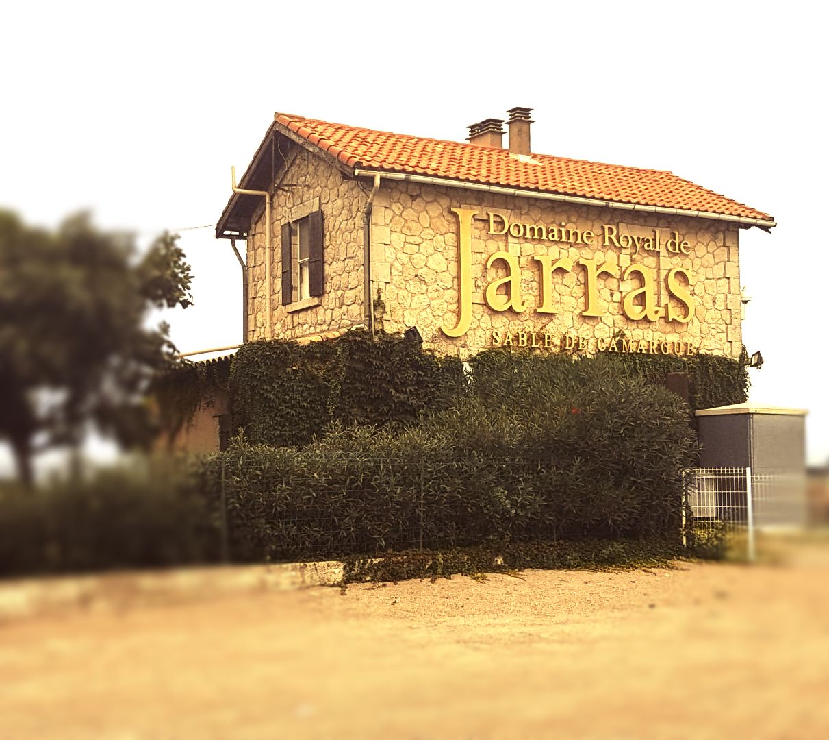Haus mit rotem Dach- An der Seite steht Weingut Jarrasein Kind surft darauf