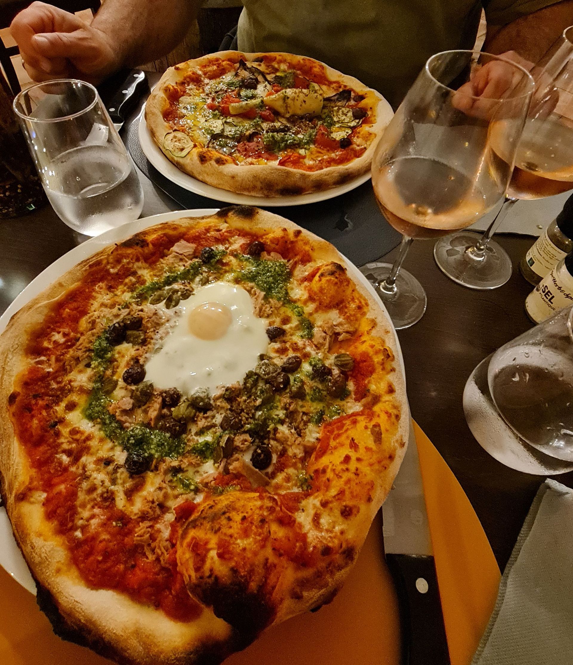 Zwei wunderschöne Pizzen auf Tellern, eine mit Spiegelei