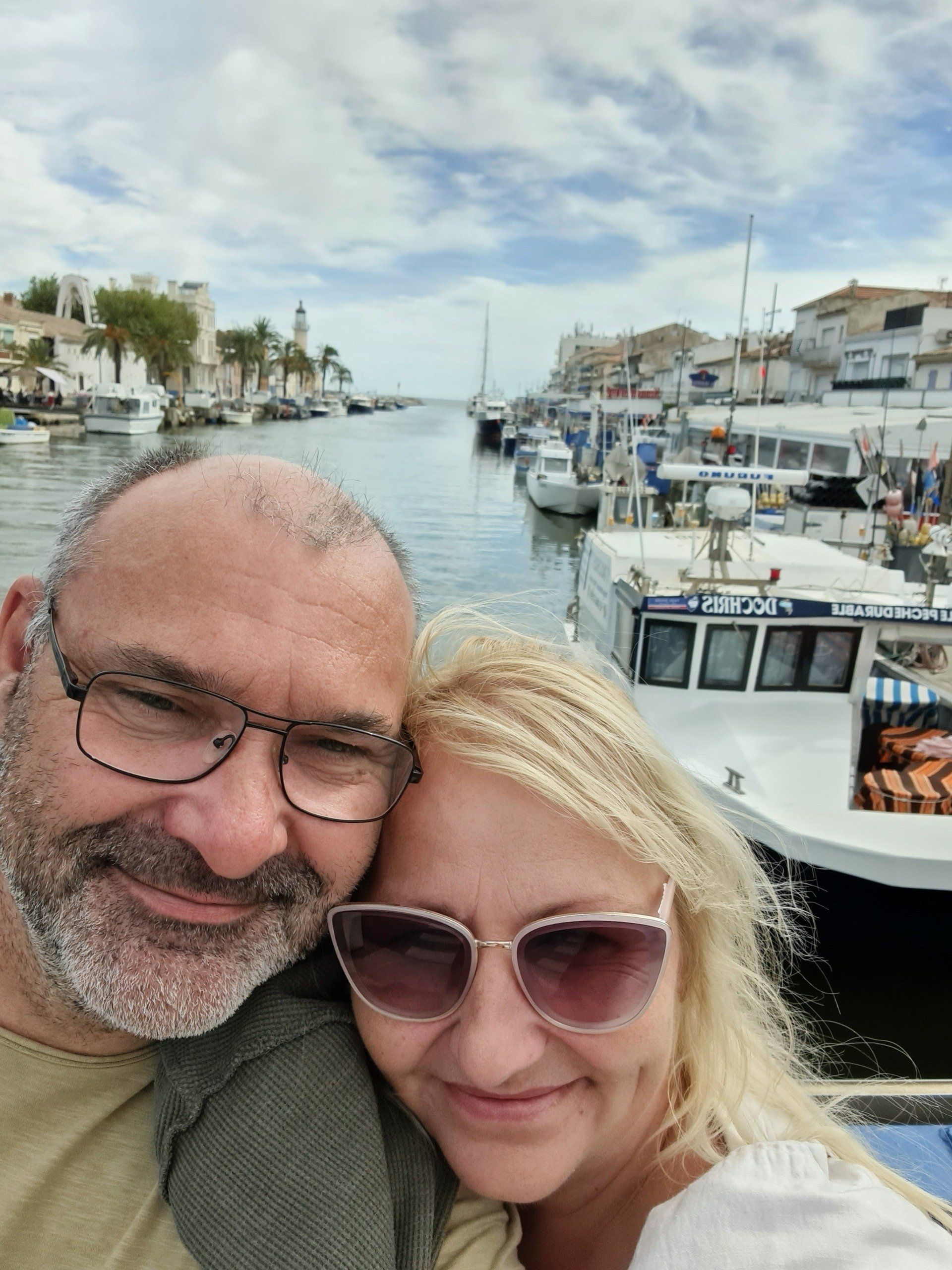 Schön, dass wir uns haben Ein Paar vor einem Kanal ins Meer, rechts und links Boote und Häuser