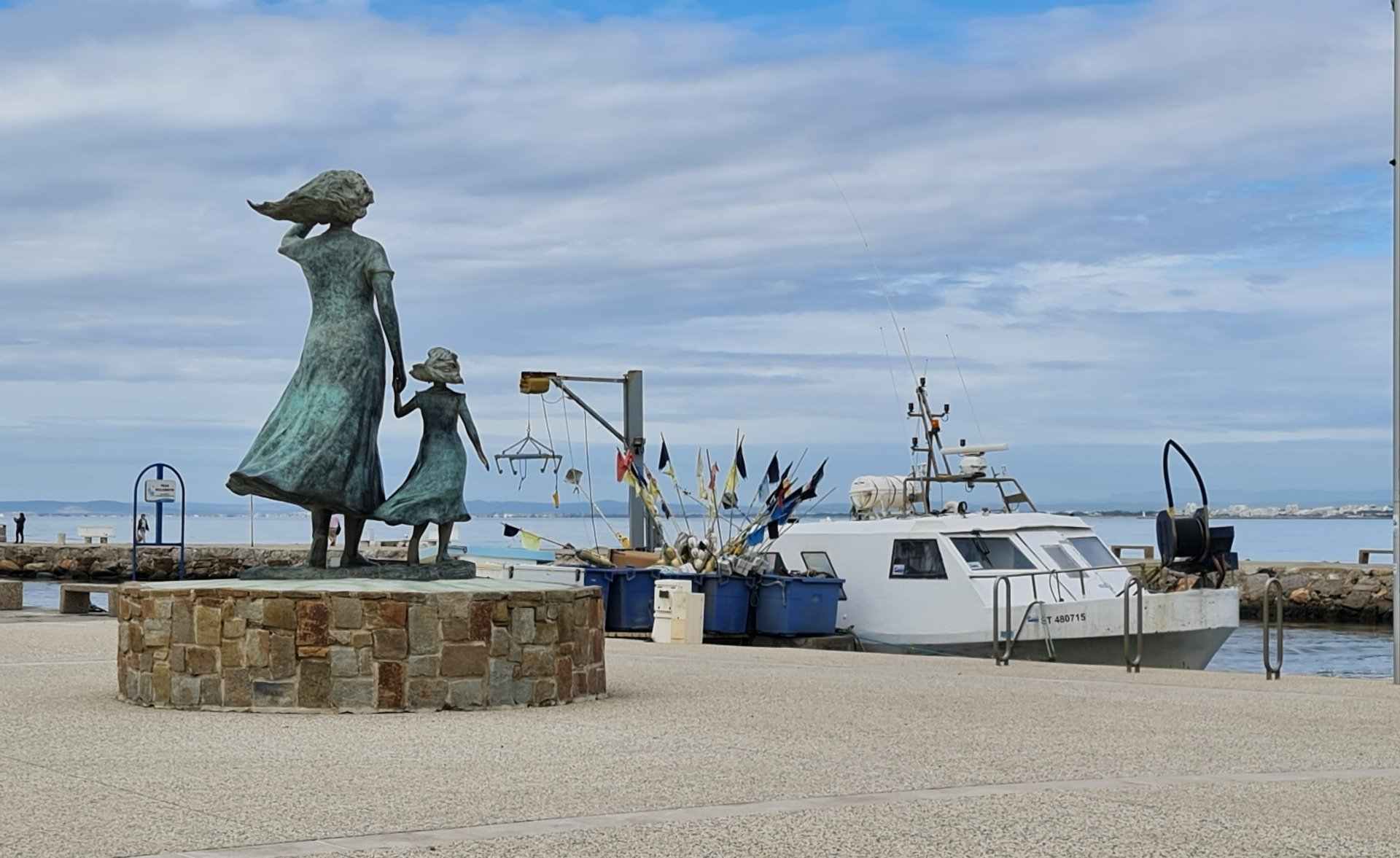 Denkmal L ´Esperance - die Hoffnung in Le 'Grau du Roi   Photo by: Viola Einert-Krug Denkmal von Frau und Tochter, die aufs Meer nach dem Fischerboot schauen, Bott am Kai