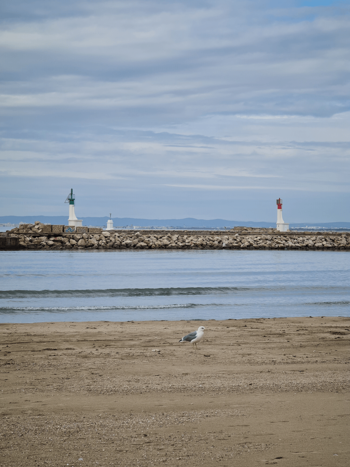 Strandabschnitt und in der Ferne die Kanaleinfahrt in Le Grau du Roi
