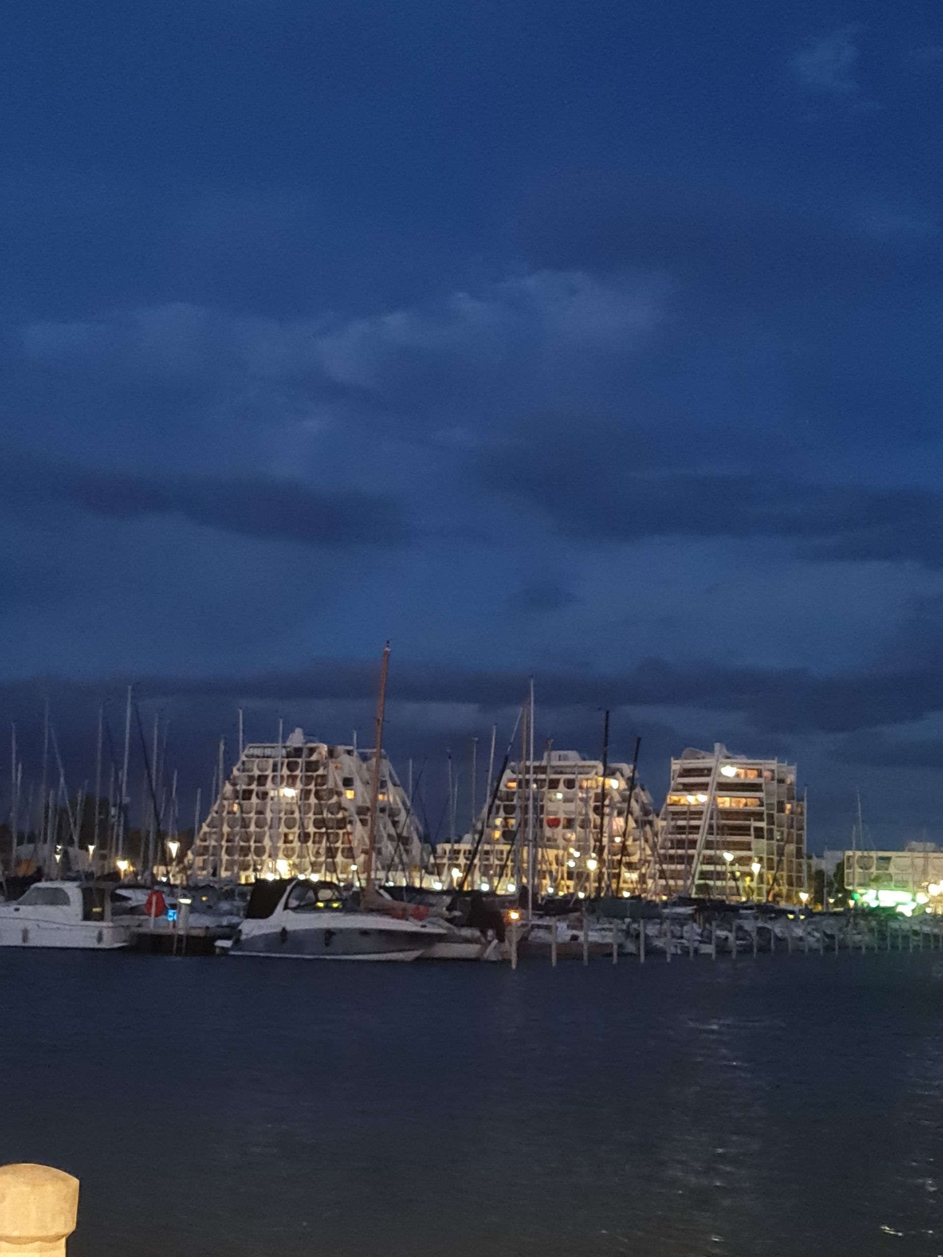 Blick bei Nacht übers Wasser auf futuristische Häuser im Süden Frankreichs