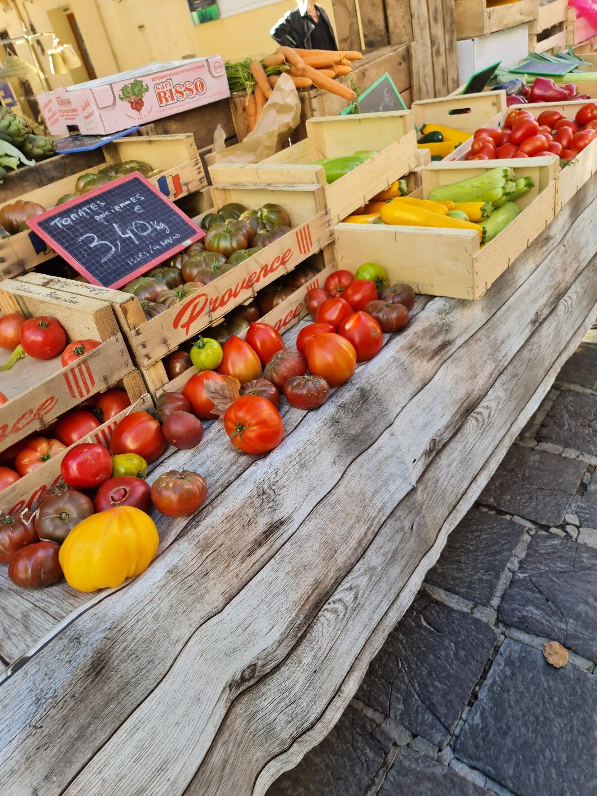 Markt in Le Grau du Roi, gelbe und verschiedene rote Tomaten, Paprika, Möhren vom Bauernhof , große und kleine, liegen mit und ohne Kisten auf einem grauen Marktstand